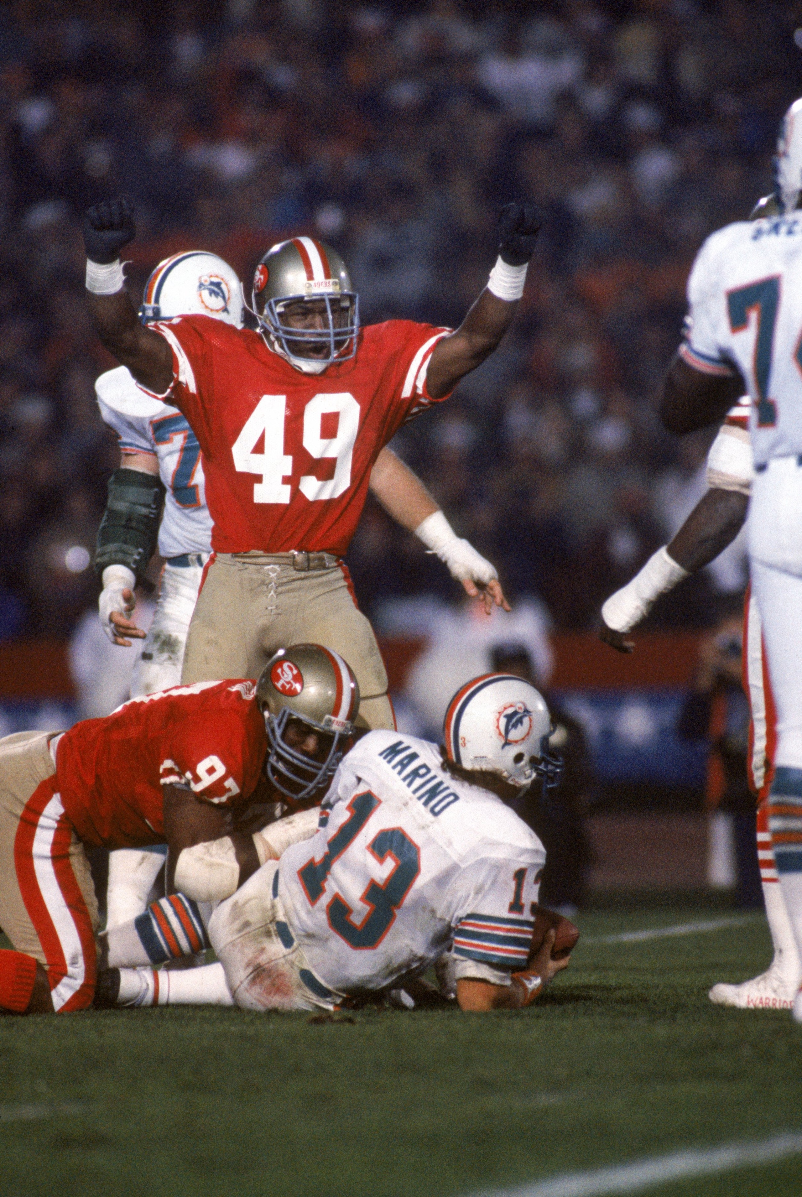 STANFORD, CA - JANUARY 20:  Linebacker Jeff Fuller #49 of the San Francisco 49ers celebrates after teaming up with teammate Gary Johnson #97 on a sack against Miami Dolphins quarterback Dan Marino #13 during Super Bowl XIX at Stanford Stadium on January 2
