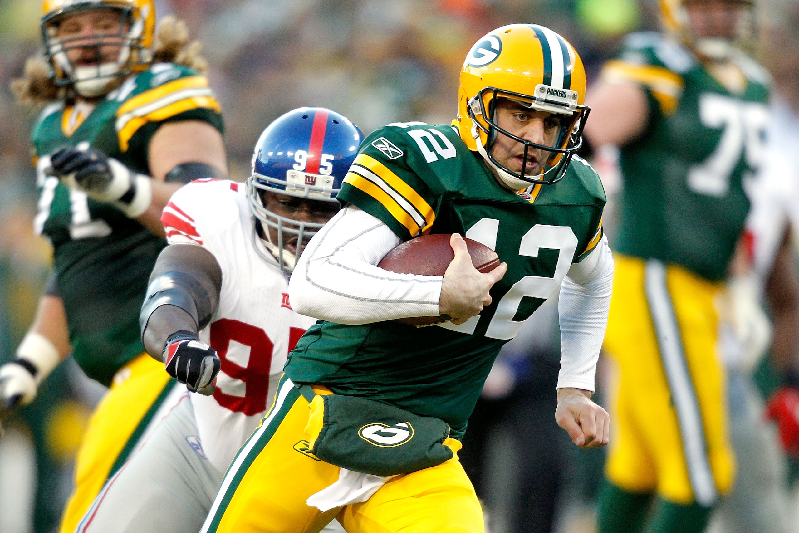 GREEN BAY, WI - DECEMBER 26:  Aaron Rodgers #12 of the Green Bay Packers is chased out of the pocket against the New York Giants at Lambeau Field on December 26, 2010 in Green Bay, Wisconsin.  (Photo by Matthew Stockman/Getty Images)