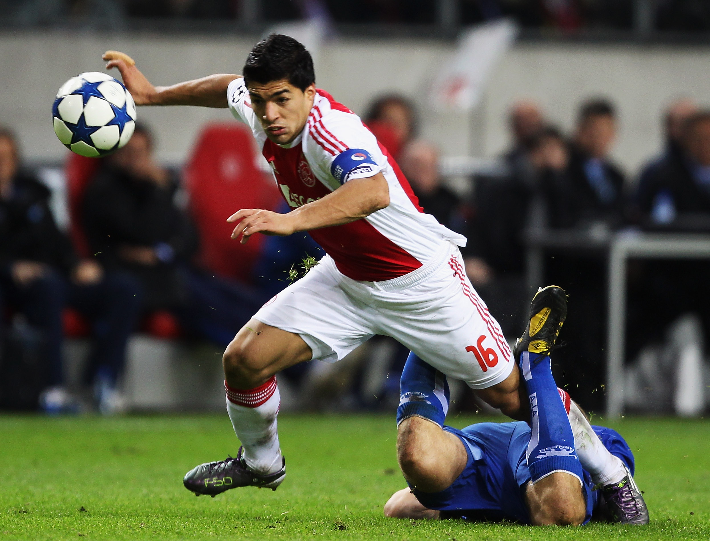 AMSTERDAM, NETHERLANDS - OCTOBER 19:  Luis Suarez of AFC Ajax steps over Stephane Grichting of AJ Auxerre during the UEFA Champions League Group G match between AFC Ajax and AJ Auxerre at the Amsterdam ArenA on October 19, 2010 in Amsterdam, Netherlands.