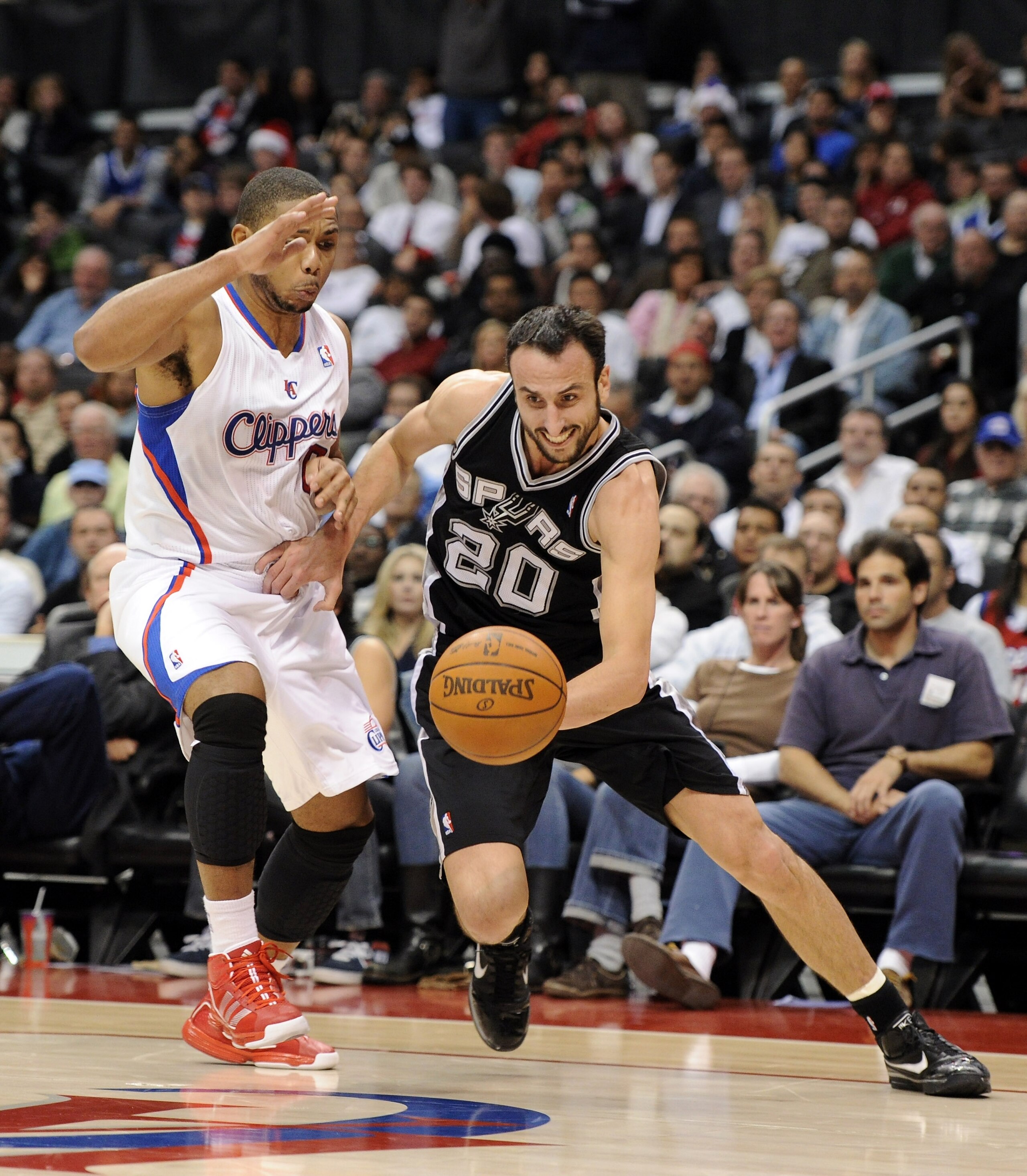 LOS ANGELES, CA - DECEMBER 01:  Manu Ginobili #20 of the San Antonio Spurs drives dribbles around Eric Gordon #10 of the Los Angeles Clippers during the game at the Staples Center on December 1, 2010 in Los Angeles, California.  NOTE TO USER: User express