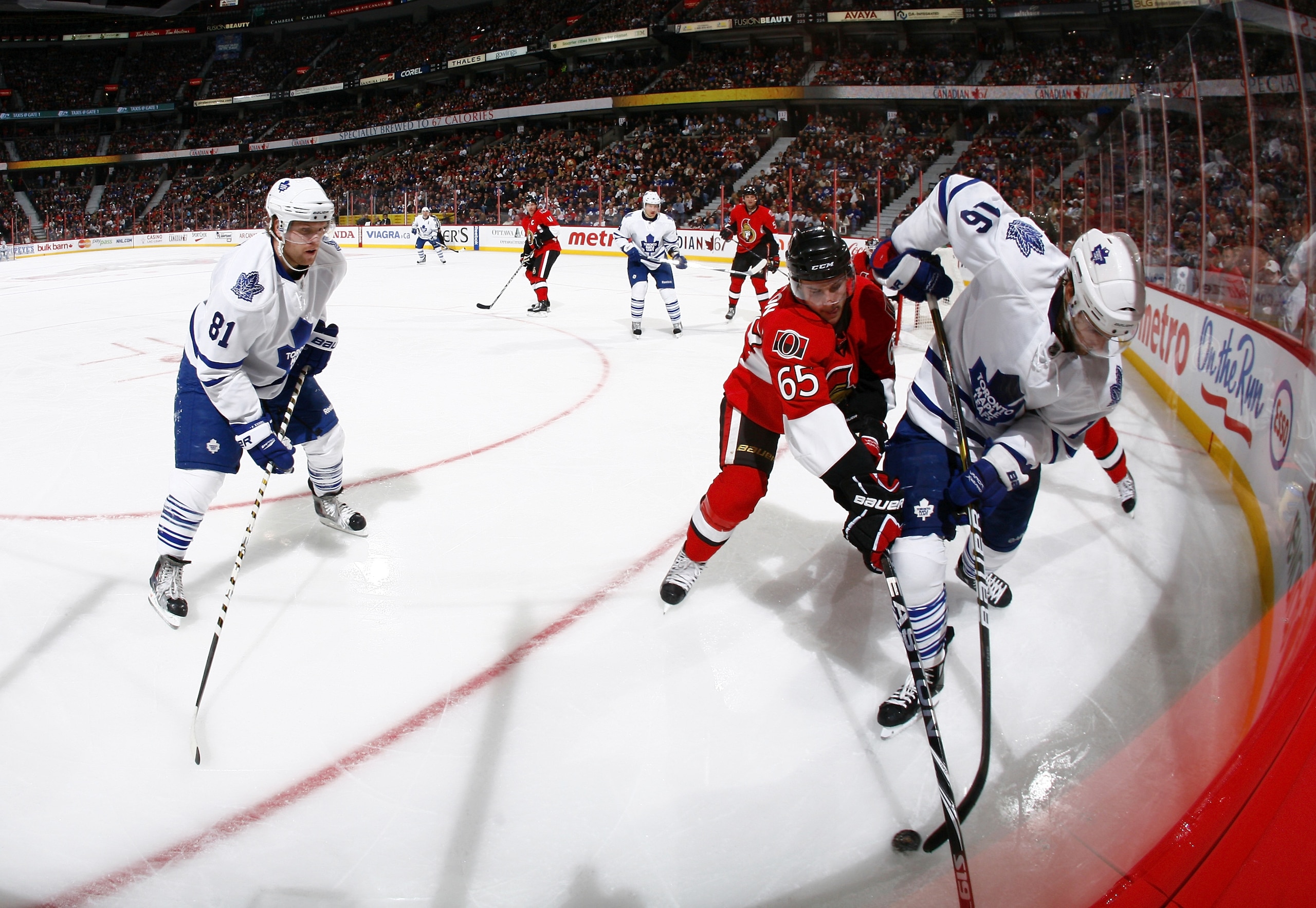OTTAWA, ON - NOVEMBER 27:  Phil Kessel #81 of the Toronto Maple Leafs waits for a pass from teammate Clarke MacArthur #16 while he battles for the puck in the corner with Erik Karlsson #65 of the Ottawa Senators during a game at Scotiabank Place on Novemb