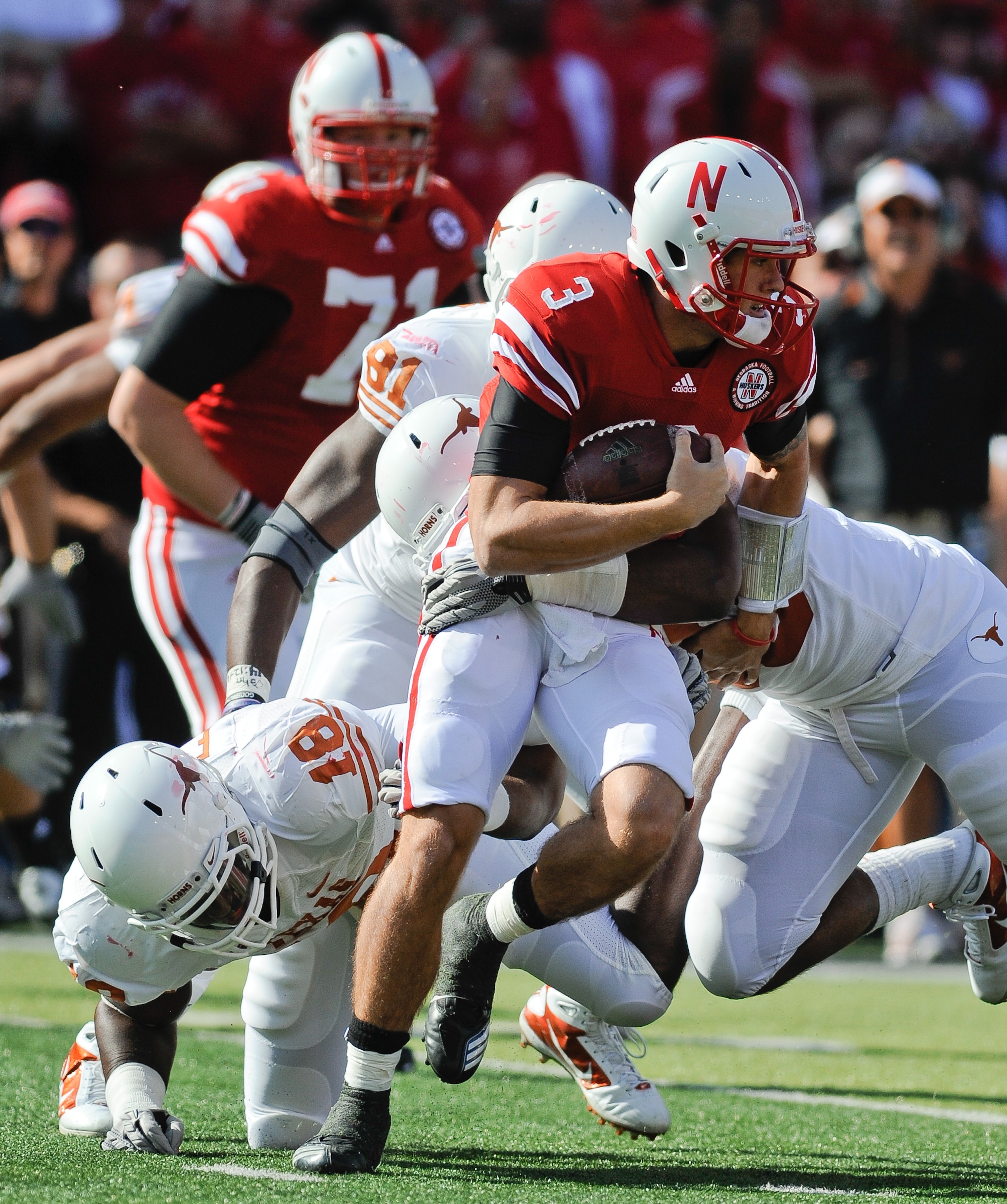 LINCOLN, NE - OCTOBER 16: Quarterback Taylor Martinez #3 of the Nebraska Cornhuskers runs from the grasp of Texas Longhorns linebacker Emmanuel Acho #18 during first half action of their game at Memorial Stadium on October 16, 2010 in Lincoln, Nebraska. T