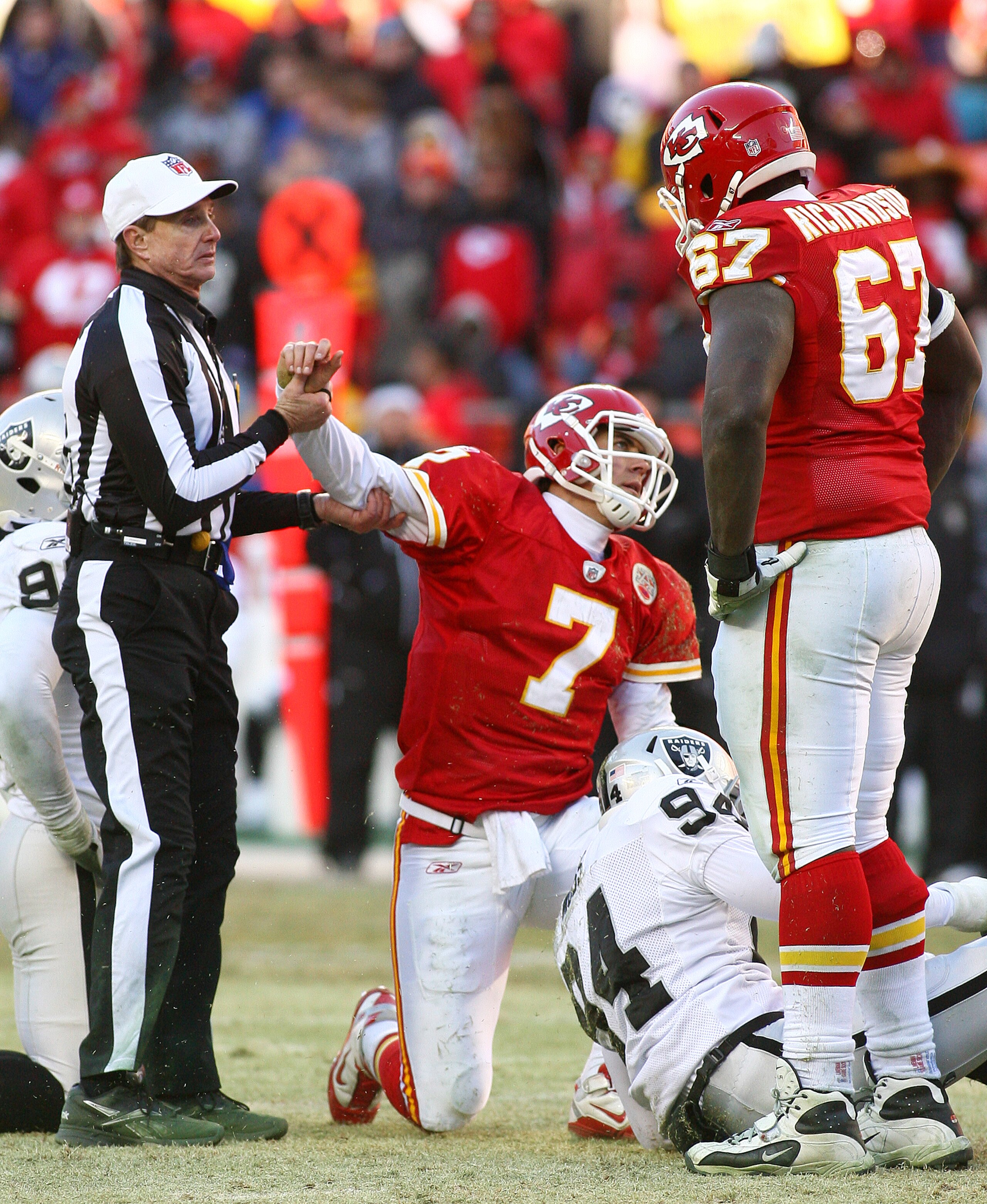 KANSAS CITY, MO - JANUARY 02:  Quarterback Matt Cassel #7 of the Kansas City Chiefs is helped off the ground by the referee after being sacked in a game against the Oakland Raiders at Arrowhead Stadium on January 2, 2011 in Kansas City, Missouri.  The Rai