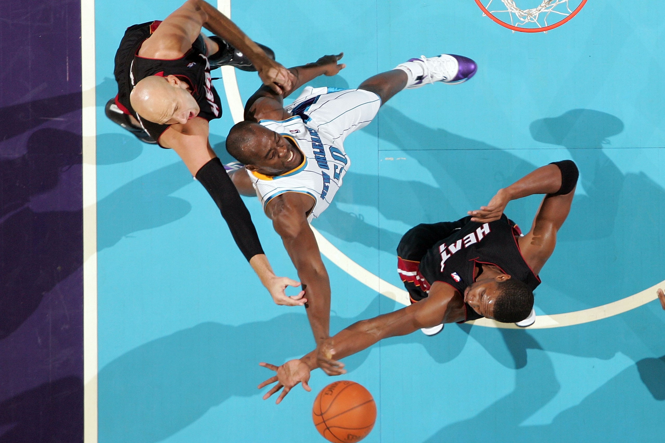 NEW ORLEANS - NOVEMBER 05:  Emeka Okafor #50 of the New Orleans Hornets fights for a rebound with Chris Bosh #1 and Zydrunas Ilgauskas #11 of the Miami Heat at the New Orleans Arena on November 5, 2010 in New Orleans, Louisiana.  NOTE TO USER: User expres