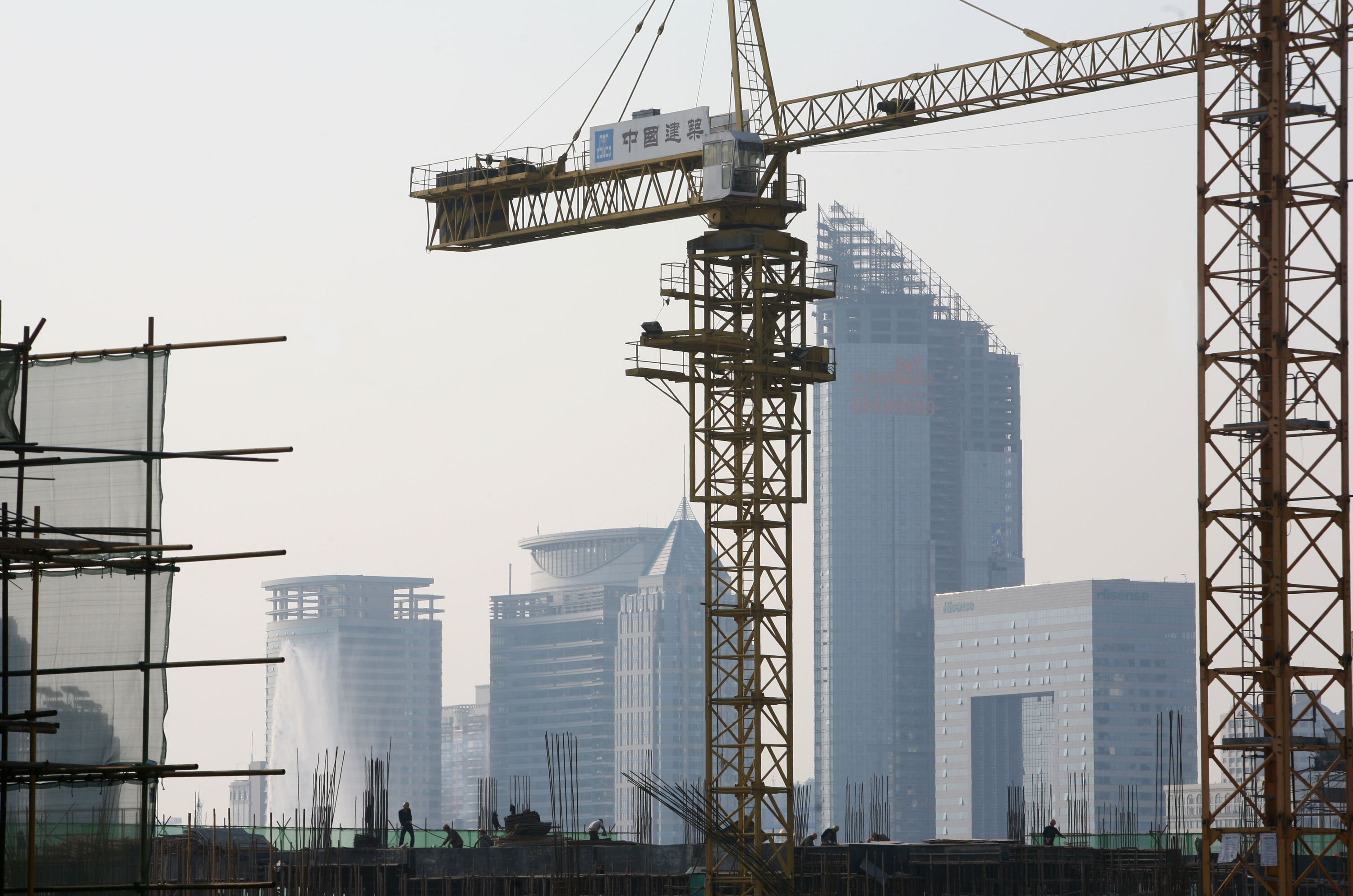 QINGDAO, CHINA - NOVEMBER 5: (CHINA OUT) Labourers work on scaffolding at the construction site of the Olympic Boulevard on November 5, 2007 in Qingdao of Shandong Province, China. Qingdao is one of co-host cities of the 2008 Olympics, where the sailing e