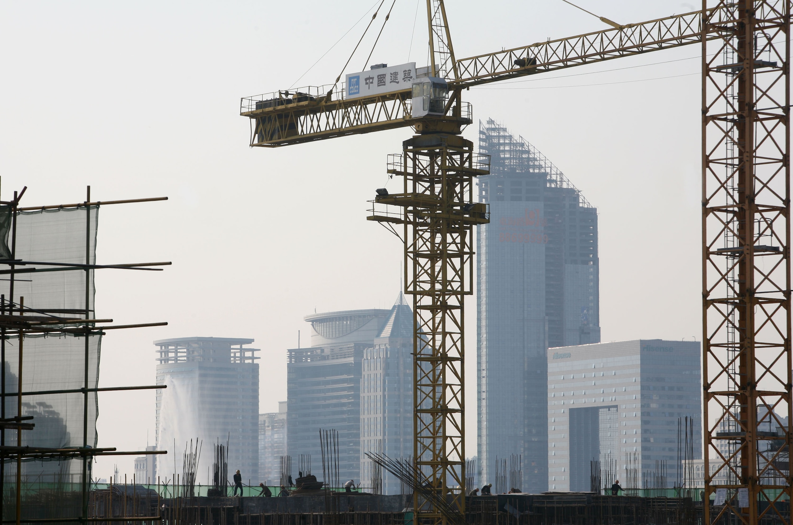 QINGDAO, CHINA - NOVEMBER 5: (CHINA OUT) Labourers work on scaffolding at the construction site of the Olympic Boulevard on November 5, 2007 in Qingdao of Shandong Province, China. Qingdao is one of co-host cities of the 2008 Olympics, where the sailing e