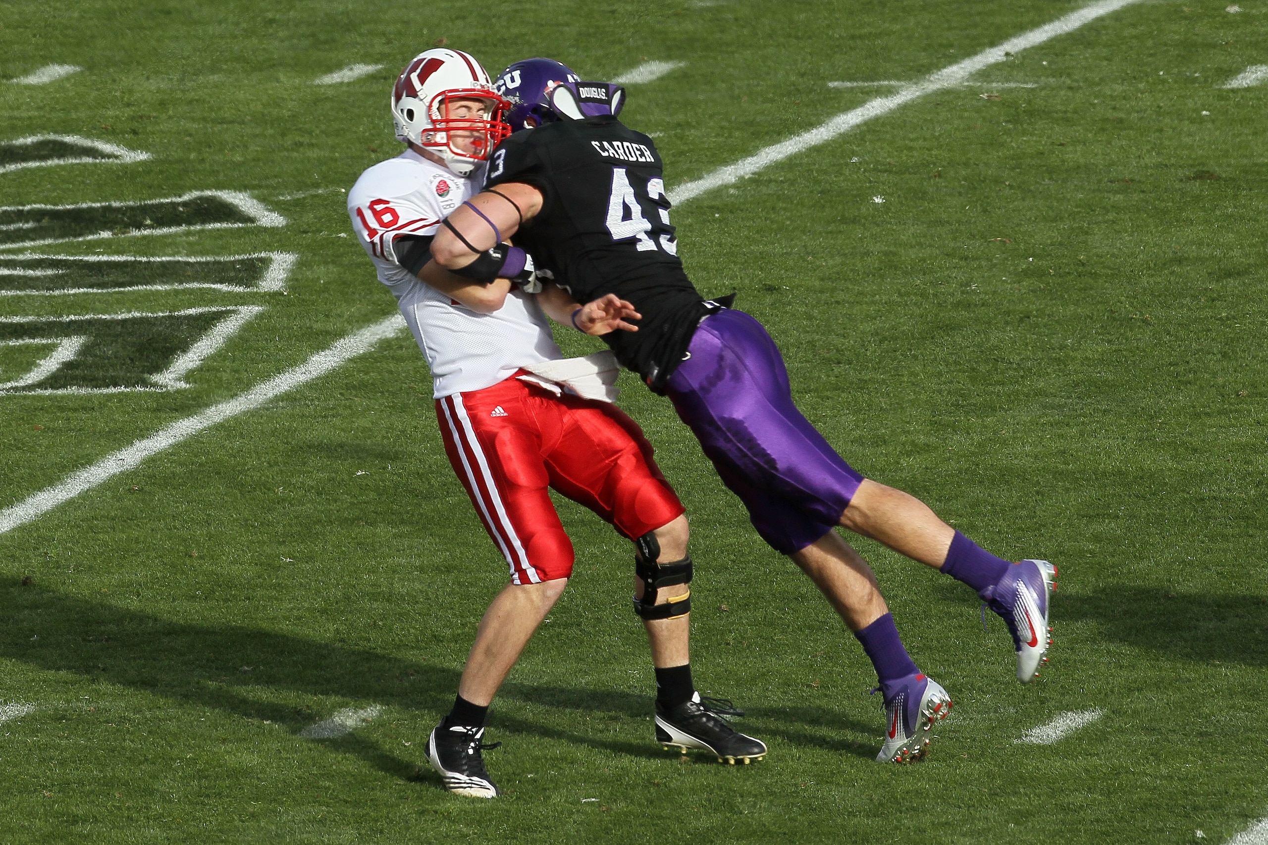 PASADENA, CA - JANUARY 01:  Quarterback Scott Tolzien #16 of the Wisconsin Badgers is hit by linebacker Tank Carder #43 of the TCU Horned Frogs during the 97th Rose Bowl game on January 1, 2011 in Pasadena, California.  (Photo by Stephen Dunn/Getty Images