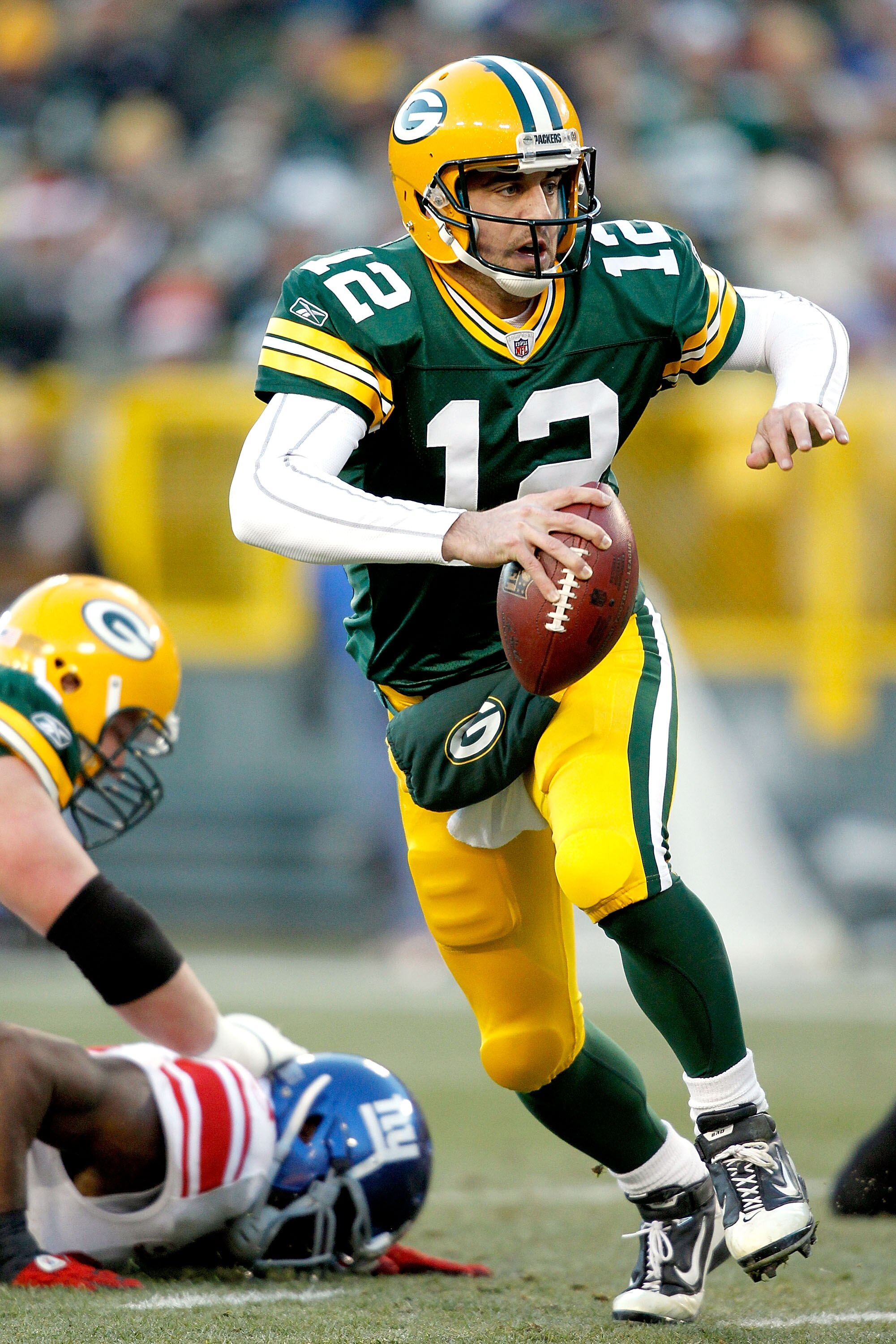 GREEN BAY, WI - DECEMBER 26:  Aaron Rodgers #12 of the Green Bay Packers is chased out of the pocket against the New York Giants at Lambeau Field on December 26, 2010 in Green Bay, Wisconsin.  (Photo by Matthew Stockman/Getty Images)