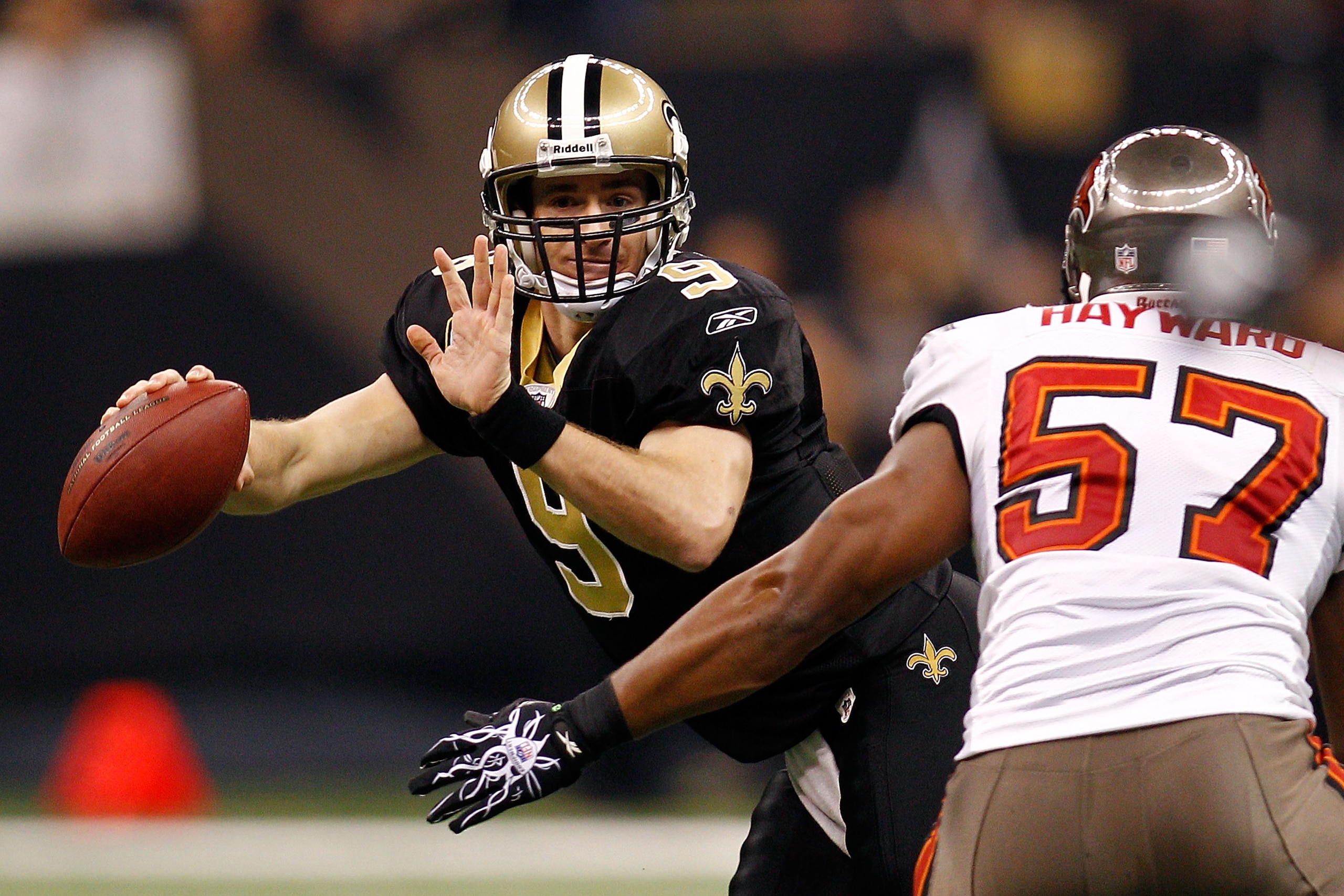NEW ORLEANS, LA - JANUARY 02:  Quarterback Drew Brees #9 of the New Orleans Saints avoids a tackle by Adam Hayward #57 of the Tampa Bay Buccaneers at the Louisiana Superdome on January 2, 2011 in New Orleans, Louisiana.  (Photo by Chris Graythen/Getty Ima