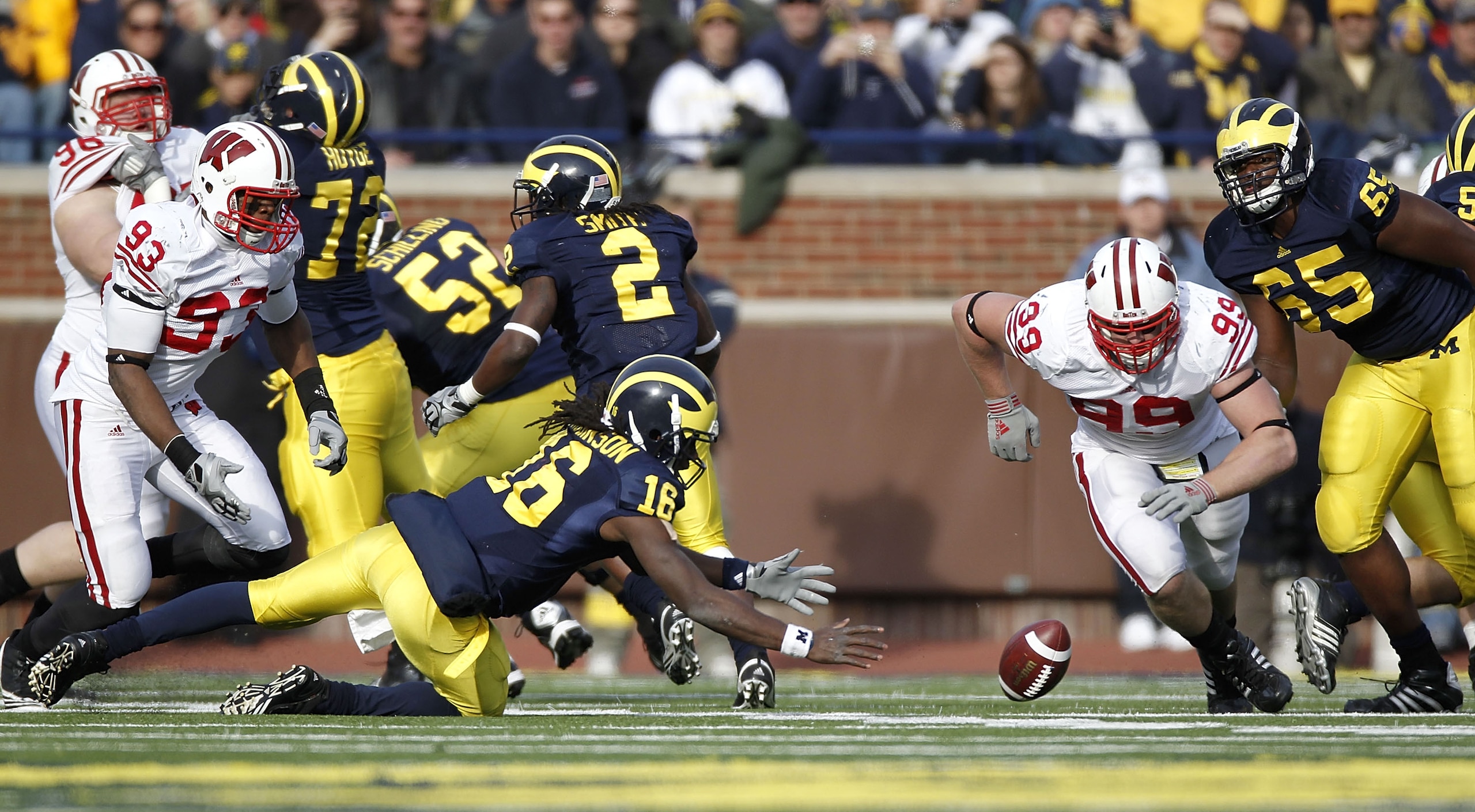 ANN ARBOR, MI - NOVEMBER 20:  Denard Robinson #16 of the Michigan Wolverines tries to beat J.J. Watt #99 of the Wisconsin Badgers to a fumble at Michigan Stadium on November 20, 2010 in Ann Arbor, Michigan. Wisconsin won the game 48-38.  (Photo by Gregory