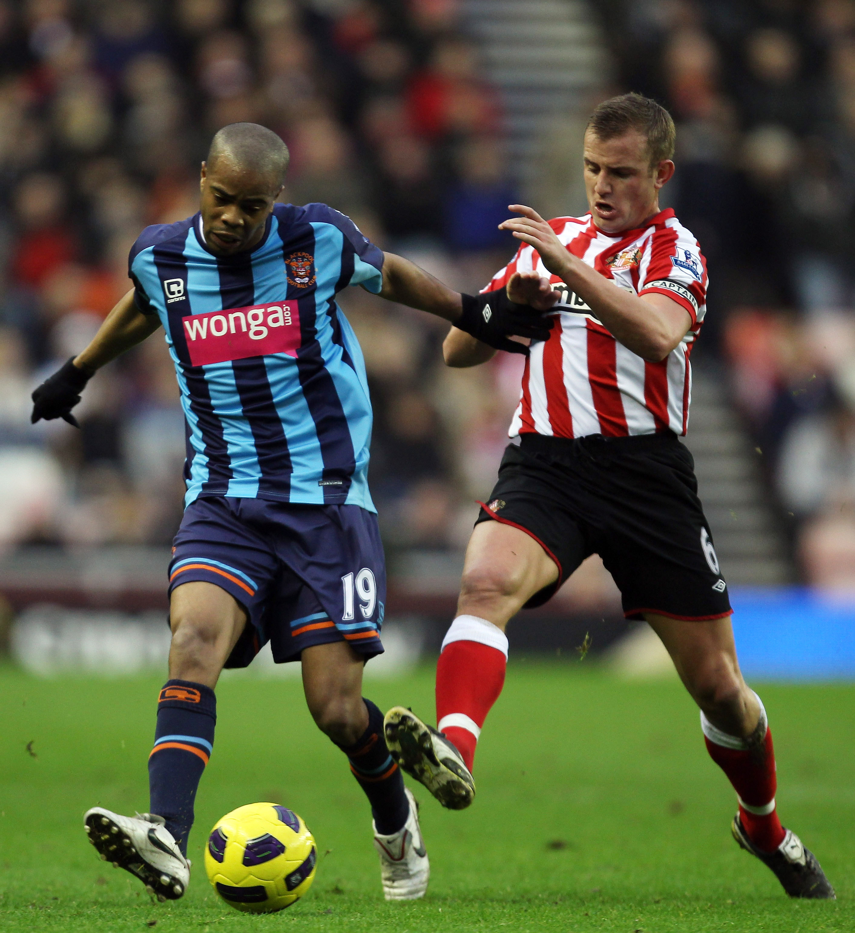 SUNDERLAND, ENGLAND - DECEMBER 28:  Lee Cattermole of Sunderland tries to tackle Ludovic Sylvestre of Blackpool during the Barclays Premier League match between Sunderland and Blackpool at the Stadium of Light on December 28, 2010 in Sunderland, England.