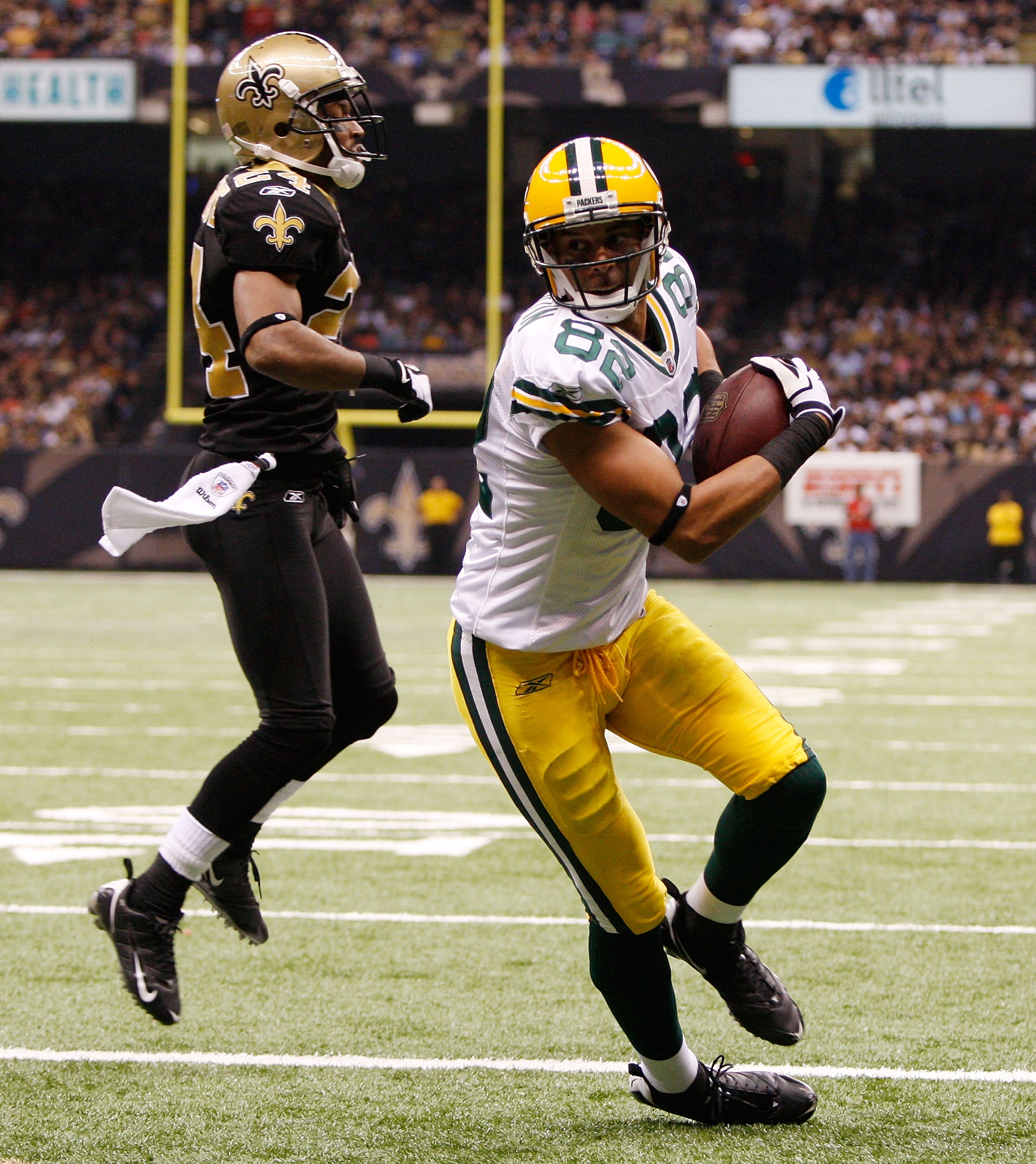 NEW ORLEANS - NOVEMBER 24:  Ruvell Martin #82 of the Green Bay Packers scores a touchdown over Leigh Torrence #24 of the New Orleans Saints on November 24, 2009 at the Superdome in New Orleans, Louisiana.  The Saints defeated the Packers 51-29.   (Photo b