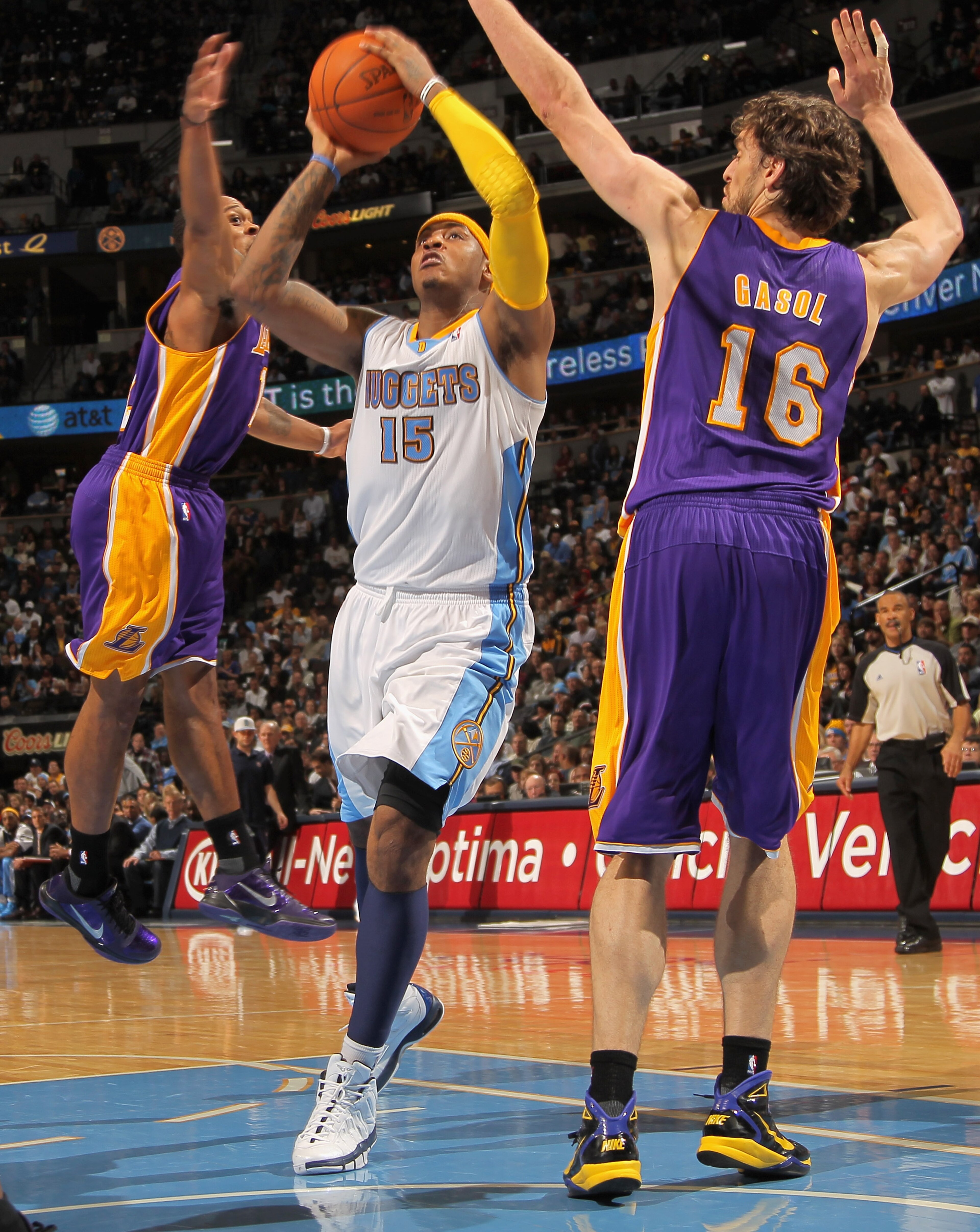 DENVER - NOVEMBER 11:  Carmelo Anthony #15 of the Denver Nuggets lays up a shot between Shannon Brown #12 and Paul Gasol #16 of the Los Angeles Lakers at the Pepsi Center on November 11, 2010 in Denver, Colorado. The Nuggets defeated the Lakers 118-112.