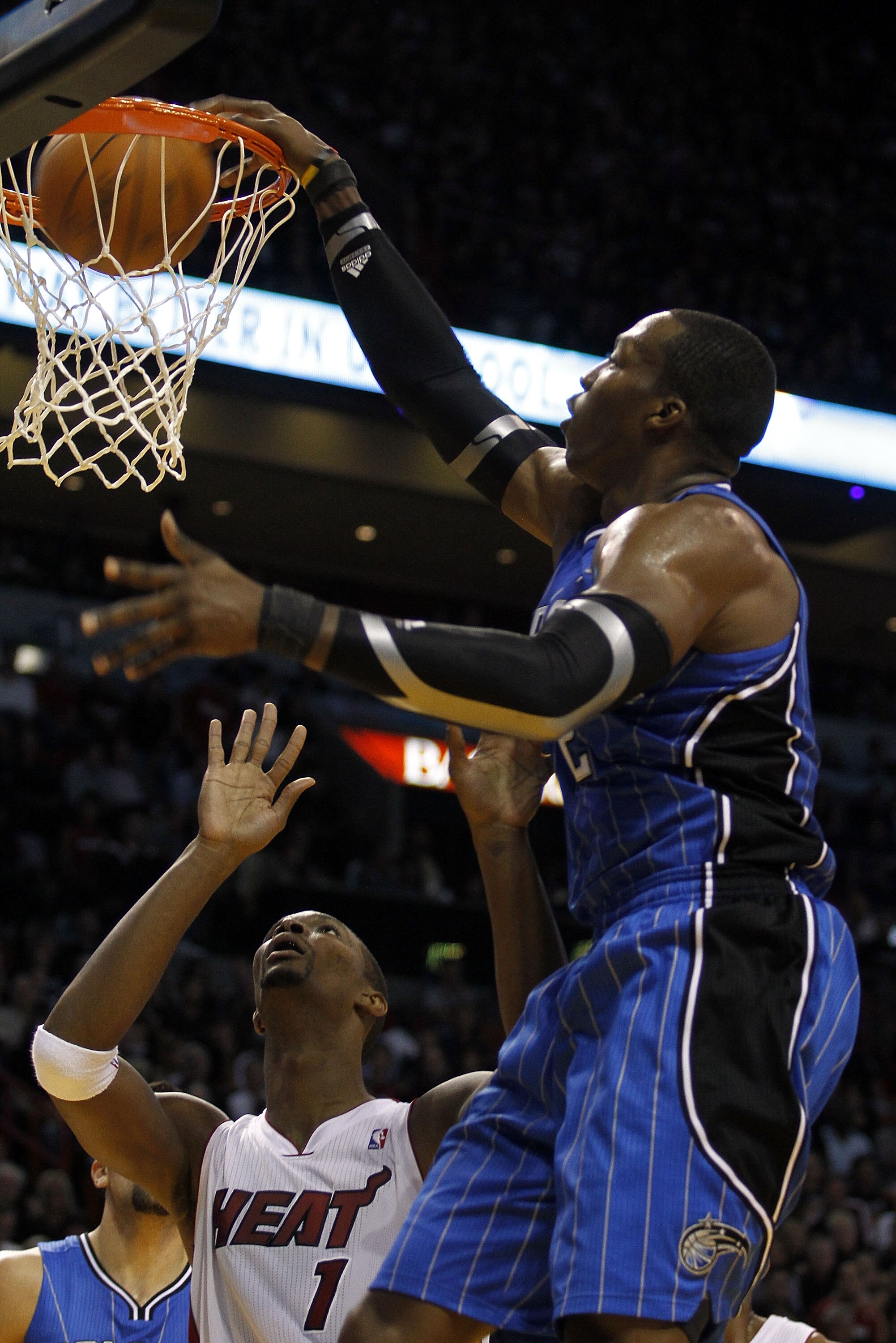 MIAMI - OCTOBER 29: Center Dwight Howard #12 of the Orlando Magic dunks against forward Chris Bosh #1 of the Miami Heat at American Airlines Arena on October 29, 2010 in Miami, Florida. NOTE TO USER: User expressly acknowledges and agrees that, by down MIAMI - OCTOBER 29: Center Dwight Howard #12 of the Orlando Magic dunks against forward Chris Bosh #1 of the Miami Heat at American Airlines Arena on October 29, 2010 in Miami, Florida. NOTE TO USER: User expressly acknowledges and agrees that, by down