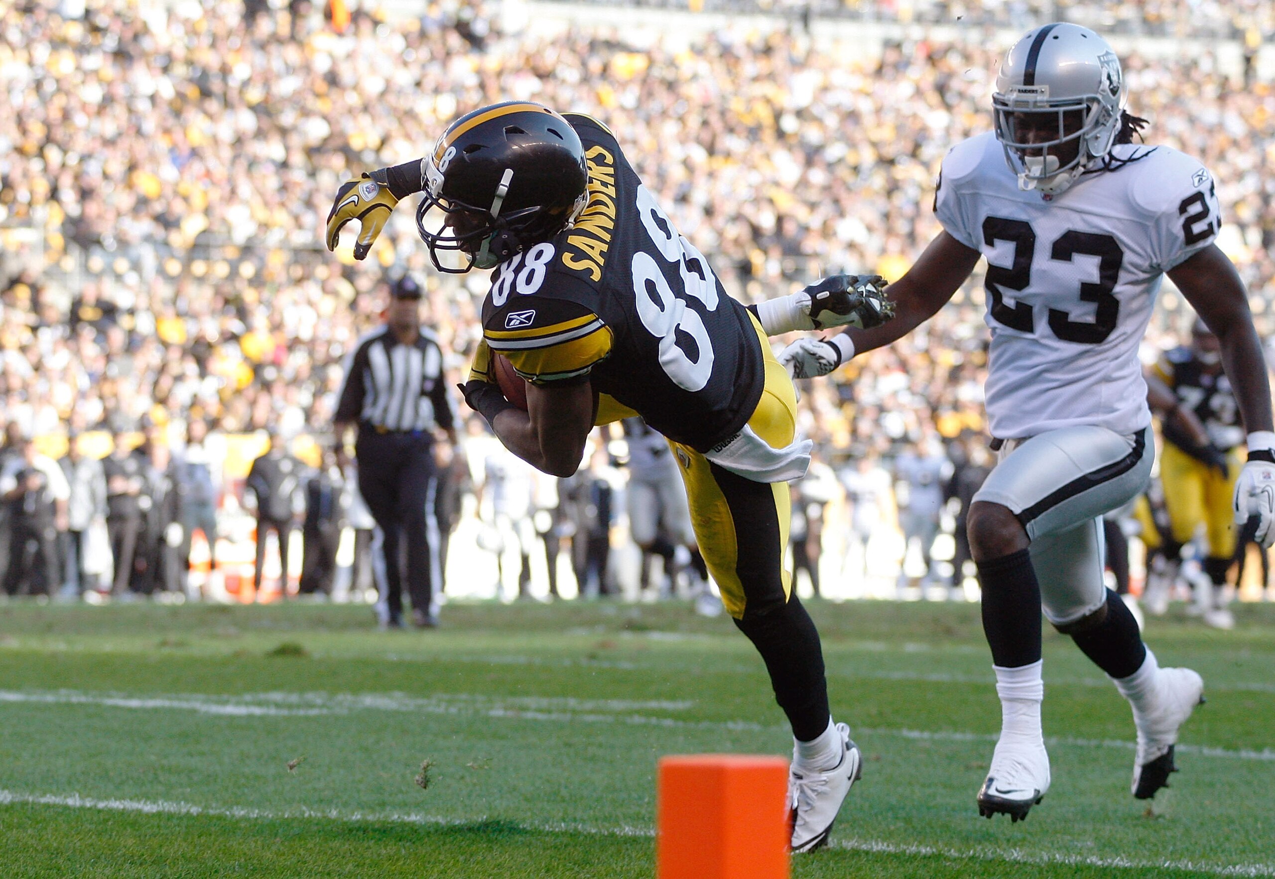 PITTSBURGH - NOVEMBER 21: Emmanuel Sanders #88 of the Pittsburgh Steelers catches a pass before rolling into the endzone for a touchdown in front of Jeremy Ware #23 of the Oakland Raiders during the game against on November 21, 2010 at Heinz Field in Pit PITTSBURGH - NOVEMBER 21: Emmanuel Sanders #88 of the Pittsburgh Steelers catches a pass before rolling into the endzone for a touchdown in front of Jeremy Ware #23 of the Oakland Raiders during the game against on November 21, 2010 at Heinz Field in Pit