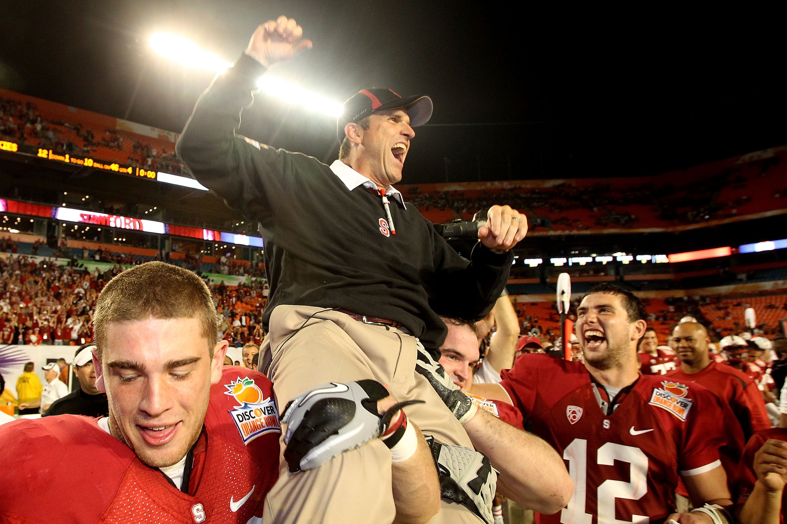 MIAMI, FL - JANUARY 03:  Head coach Jim Harbaugh of the Stanford Cardinal celebrates as he is lifted up by his players including Orange Bowl MVP Andrew Luck #12 (R) after Stanford won 40-12 against the Virginai Tech Hokies during the 2011 Discover Orange