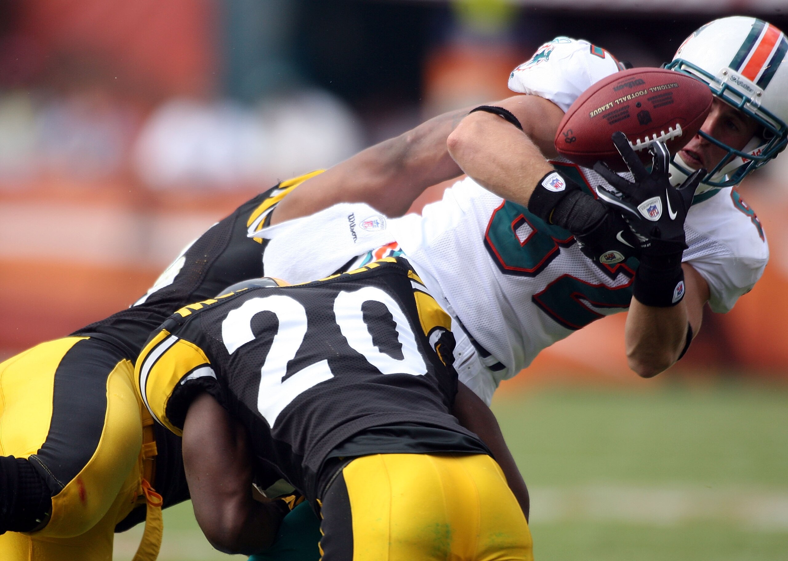 MIAMI - OCTOBER 24:  Receiver Brian Hartline #82 fumbles after being hit by cornerback Bryant Mcfadden #20 of the Pittsburgh Steelers  at Sun Life Stadium on October 24, 2010 in Miami, Florida.  (Photo by Marc Serota/Getty Images)