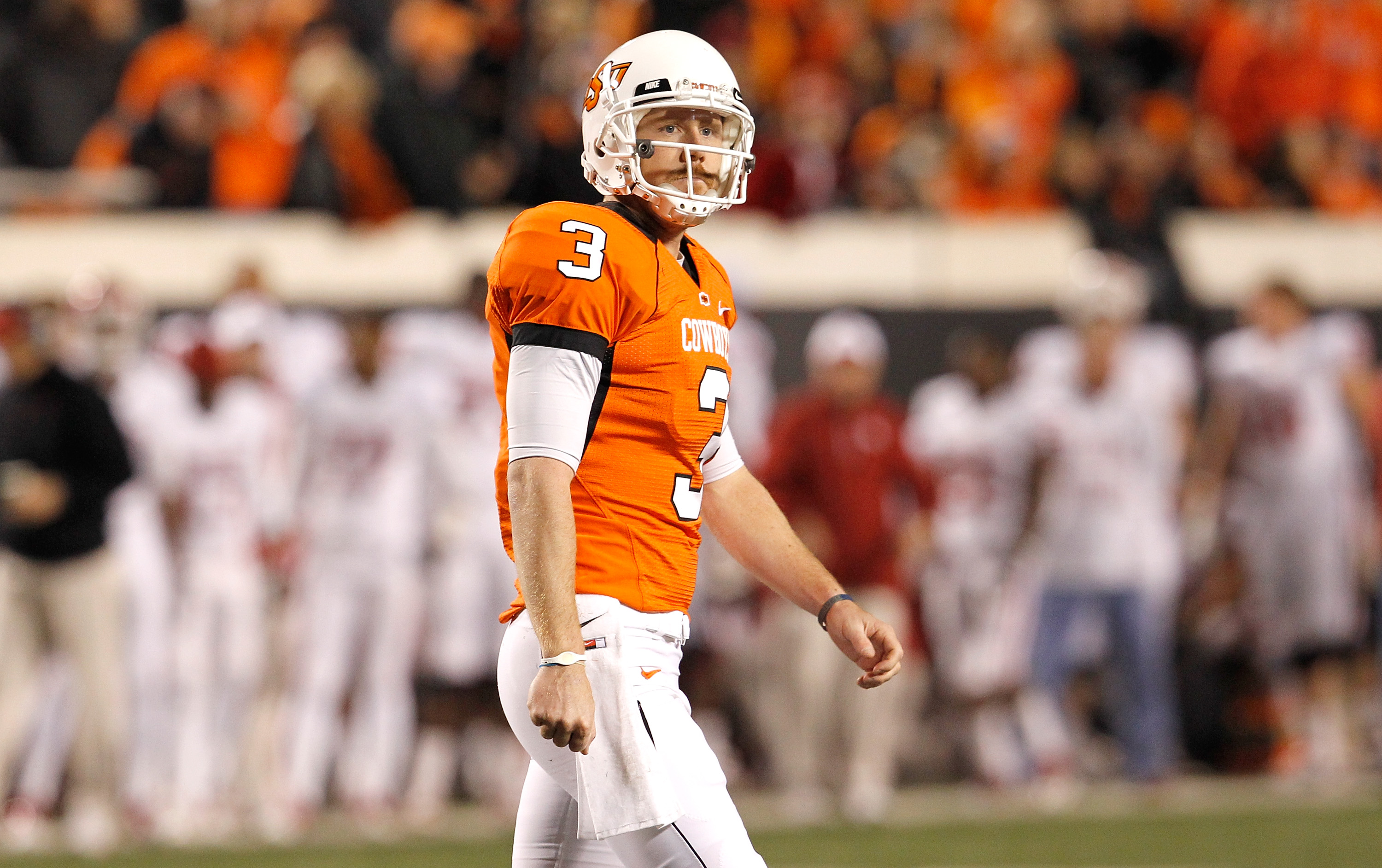 STILLWATER, OK - NOVEMBER 27:  Quarterback Brandon Weeden #3 of the Oklahoma State Cowboys walks off the field after failing to make a first down against the Oklahoma Sooners at Boone Pickens Stadium on November 27, 2010 in Stillwater, Oklahoma.  (Photo b