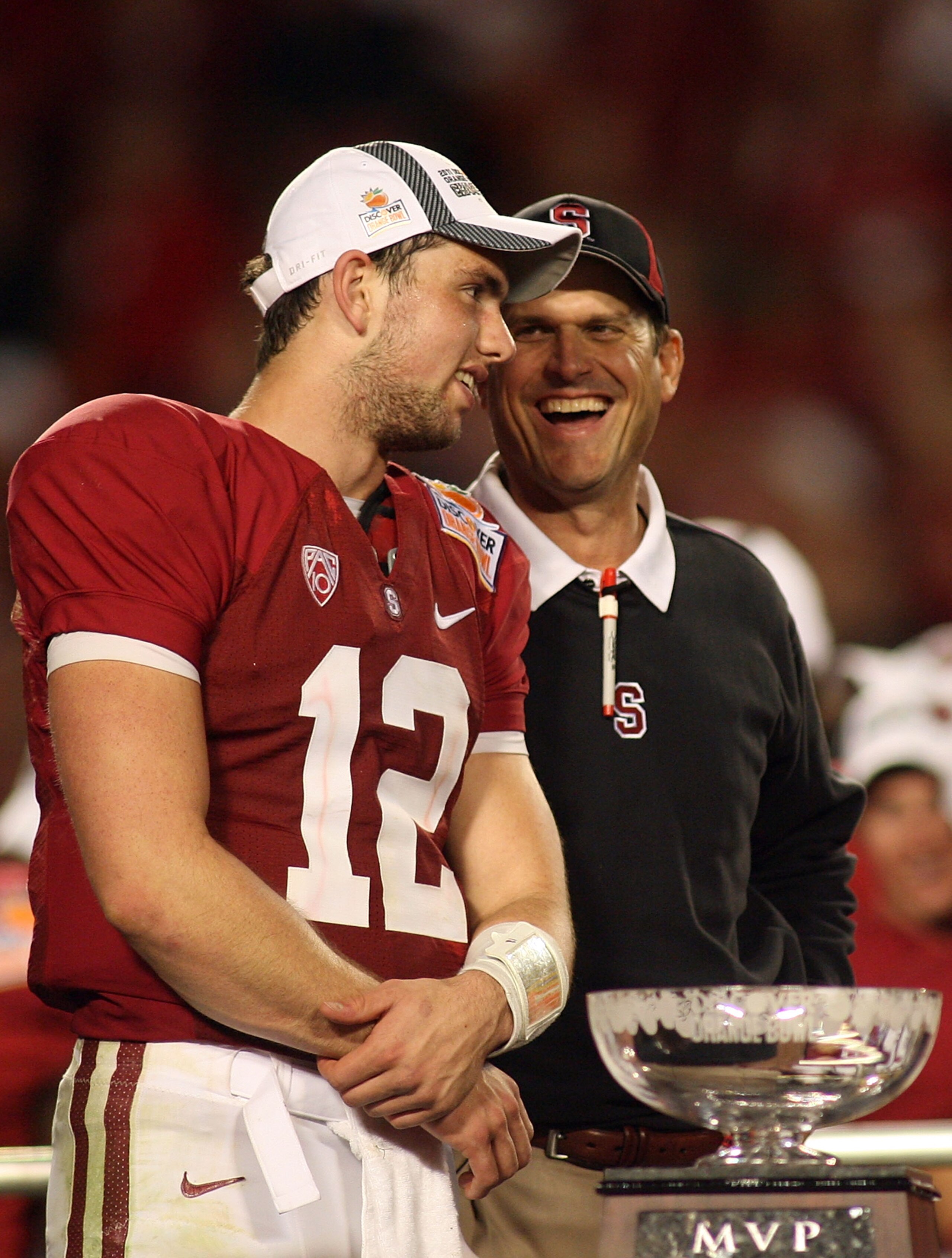 MIAMI, FL - JANUARY 03:  (L-R) Quarterback Andrew Luck and head coach Jim Harbaugh of the Stanford Cardinal celebrate with the trophy on stage after Stanford won 40-12 against the Virginai Tech Hokies during the 2011 Discover Orange Bowl at Sun Life Stadi