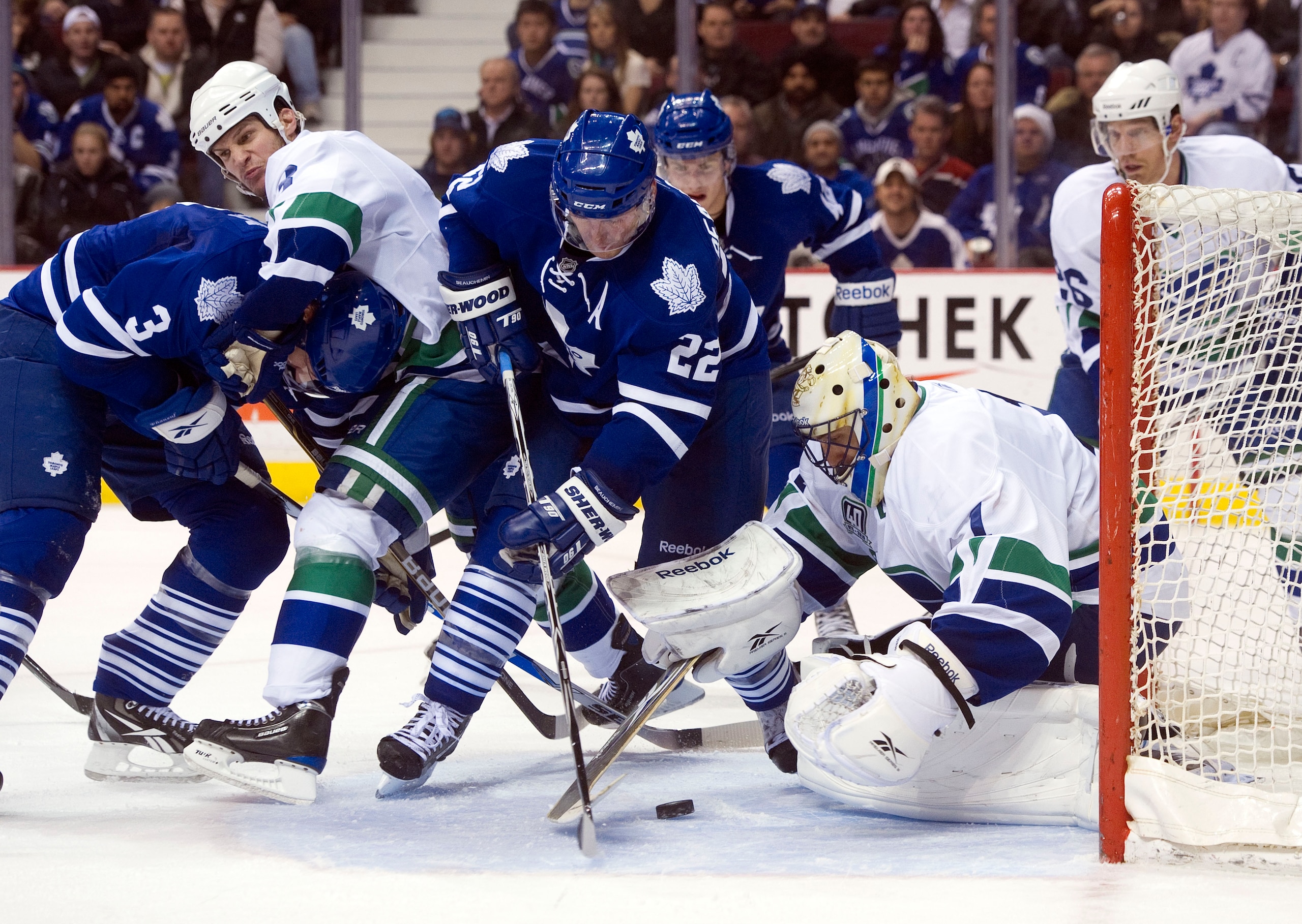 VANCOUVER, CANADA - DECEMBER 18: Francois Beauchemin #22 of the Toronto Maple Leafs tries to get a shot on goalie Roberto Luongo #1 of the Vancouver Canucks  during the third period in NHL action on December 18, 2010 at Rogers Arena in Vancouver, BC, Cana