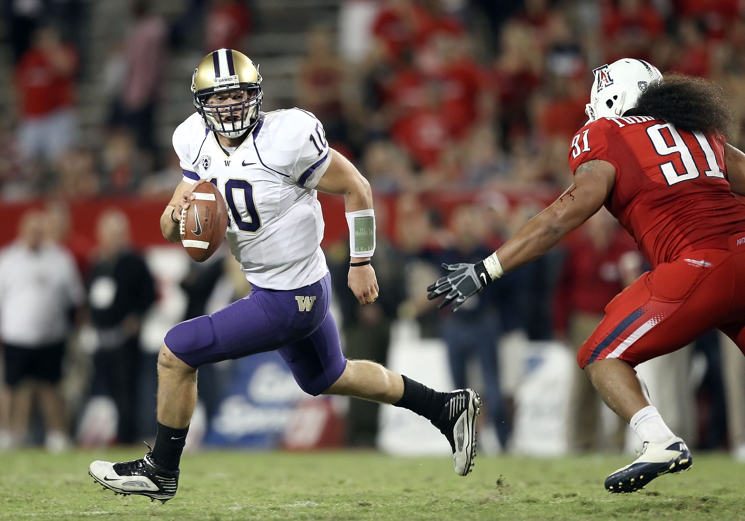 TUCSON, AZ - OCTOBER 23: Quarterback Jake Locker #10 of the Washington Huskies scrambles with the football during the college football game against the Arizona Wildcats at Arizona Stadium on October 23, 2010 in Tucson, Arizona. (Photo by Christian Peter TUCSON, AZ - OCTOBER 23: Quarterback Jake Locker #10 of the Washington Huskies scrambles with the football during the college football game against the Arizona Wildcats at Arizona Stadium on October 23, 2010 in Tucson, Arizona. (Photo by Christian Peter