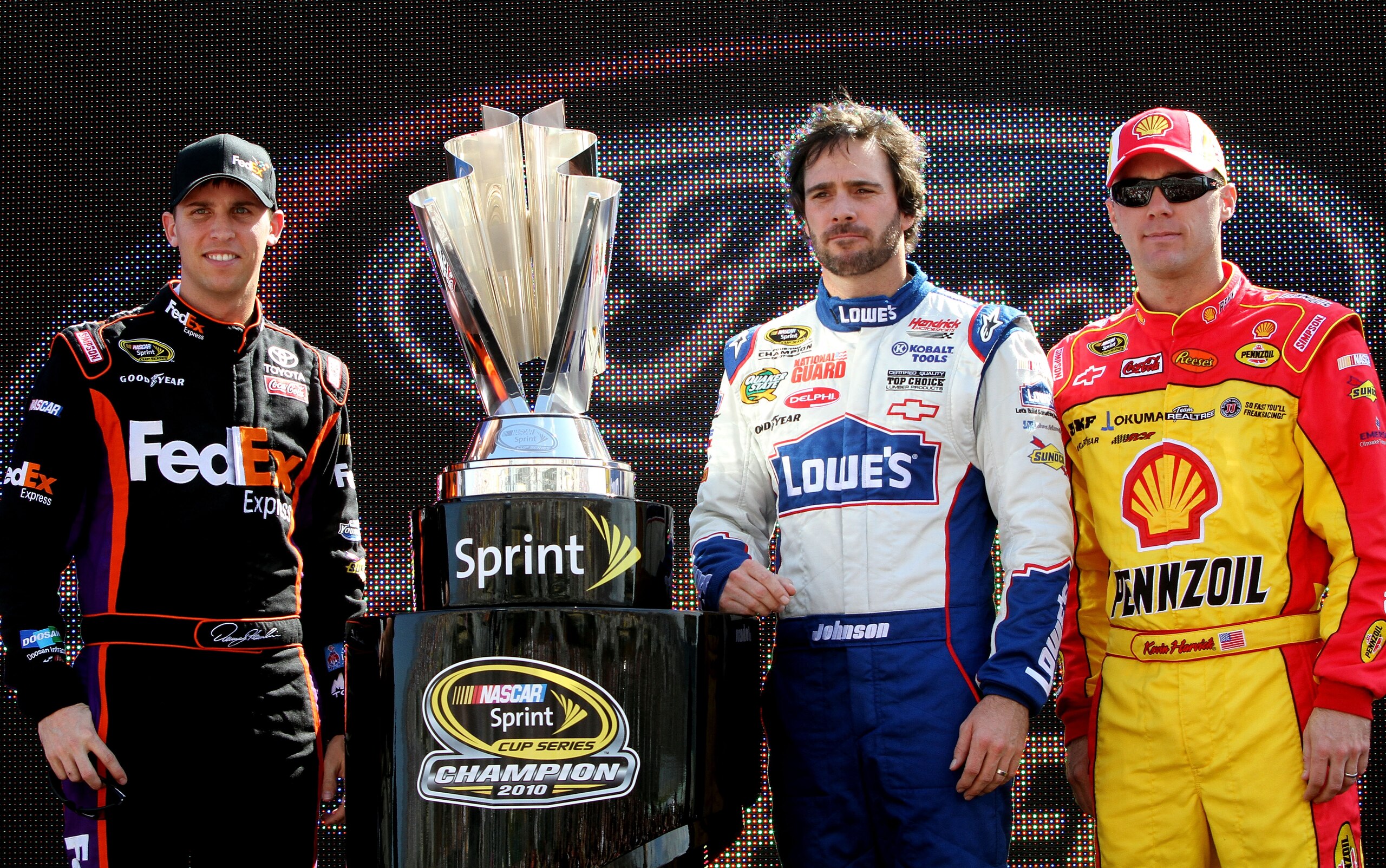 HOMESTEAD, FL - NOVEMBER 21:  (L-R) Denny Hamlin, driver of the #11 FedEx Toyota, stands next to the Sprint Cup trophy with Jimmie Johnson, driver of the #48 Lowe's Chevrolet, and Kevin Harvick, driver of the #29 Shell/Pennzoil Chevrolet, during the NASCA