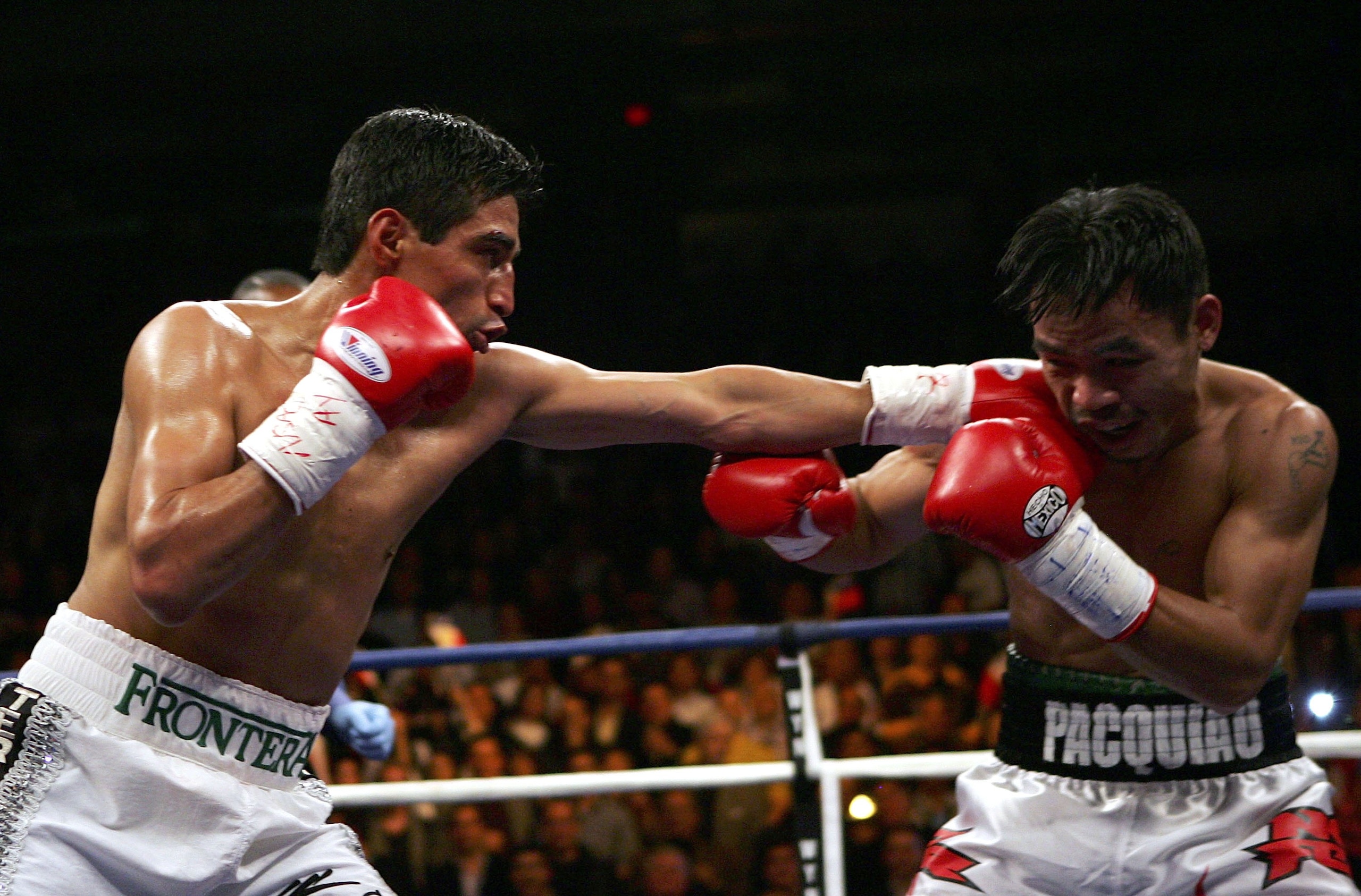 LAS VEGAS - JANUARY 21:  (L-R) Erik Morales of Mexico throws a left at Manny Pacquiao of the Phillippines during their Super Featherweight Championship fight at Thomas & Mack Arena on January 21, 2006 in Las Vegas, Nevada. (Photo by Jed Jacobsohn/Getty Im