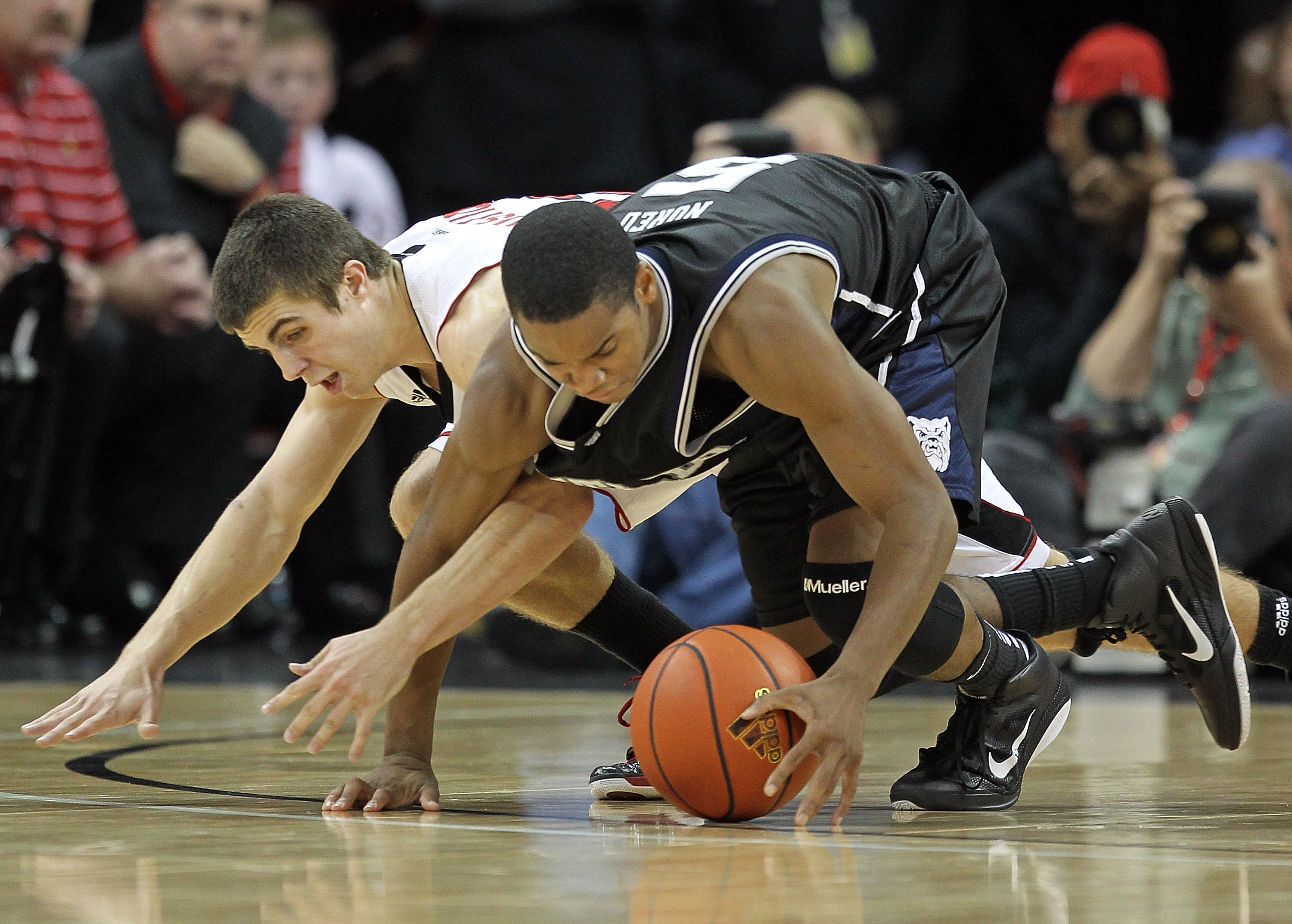 LOUISVILLE, KY - NOVEMBER 16:  Ronald Nored #5  of the Butler Bulldogs and Elisha Justice #22 of the Louisville Cardinals battle for a loose ball during the game at the KFC Yum! Center on November 16, 2010 in Louisville, Kentucky.  (Photo by Andy Lyons/Ge
