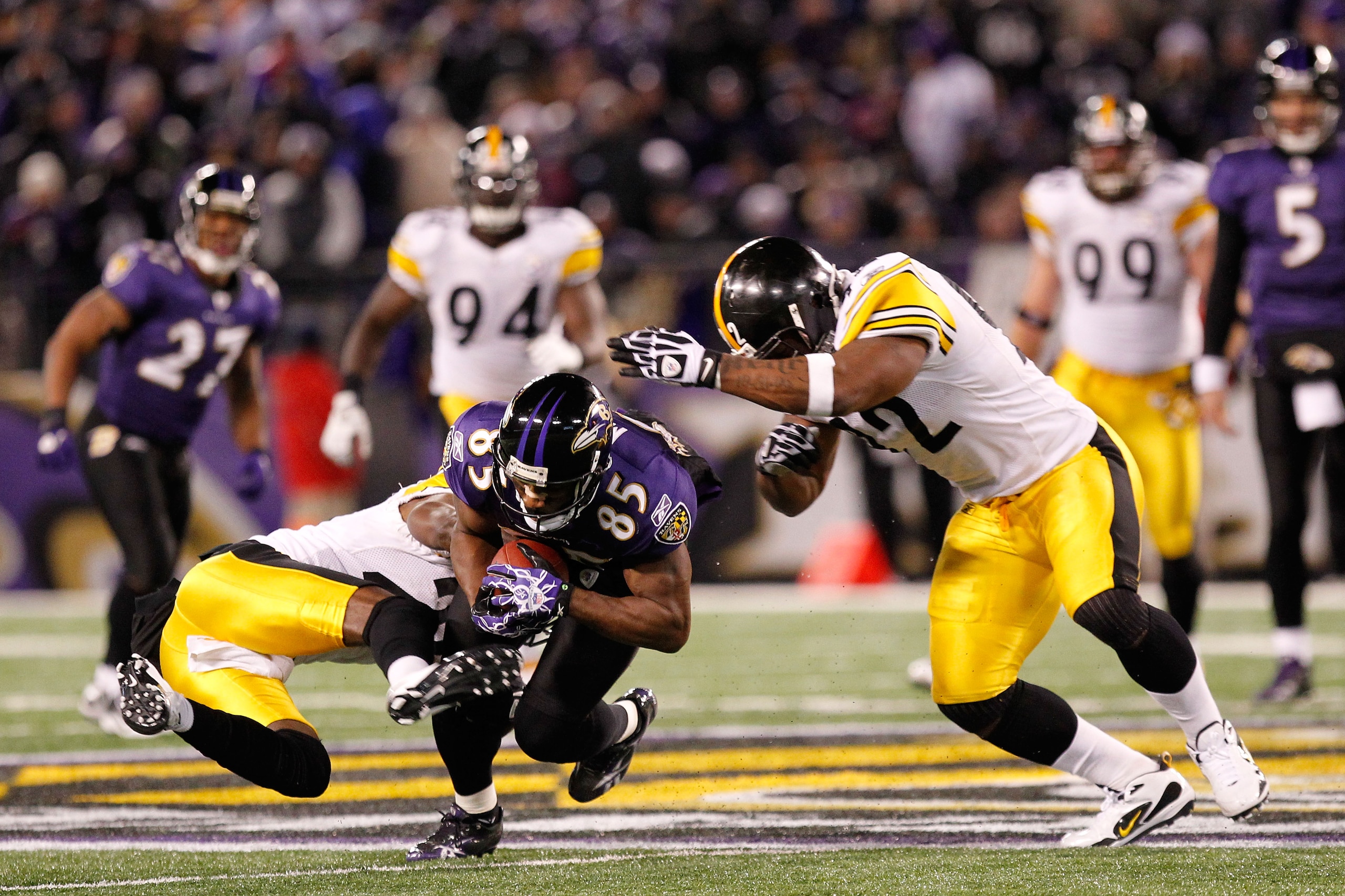 BALTIMORE, MD - DECEMBER 05:  Wide receiver Derrick Mason #85 of the Baltimore Ravens is tackled by safety Ryan Clark #25 of the Pittsburgh Steelers during the second quarter of the game at M&T Bank Stadium on December 5, 2010 in Baltimore, Maryland. Pitt
