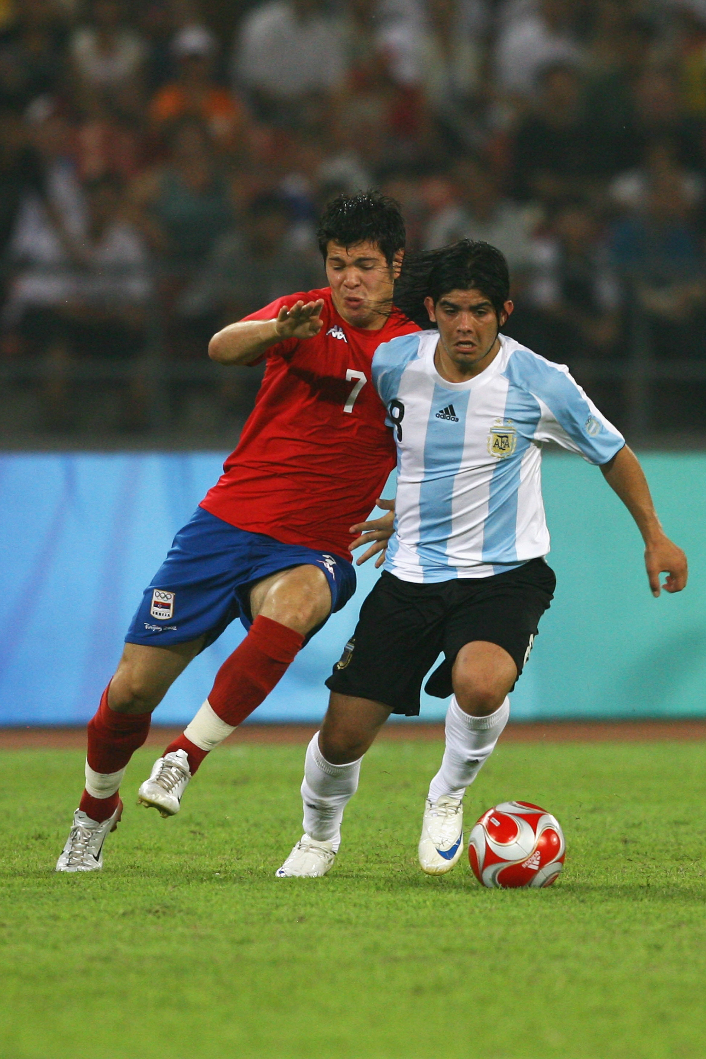 BEIJING - AUGUST 13:  Ever Banega of Argentina is tackled by Milan Smiljanic #7 of Serbia during the Men's First Round Group A match between Argentina and Serbia at the Workers' Stadium on Day 5 of the Beijing 2008 Olympic Games on August 13, 2008 in Beij