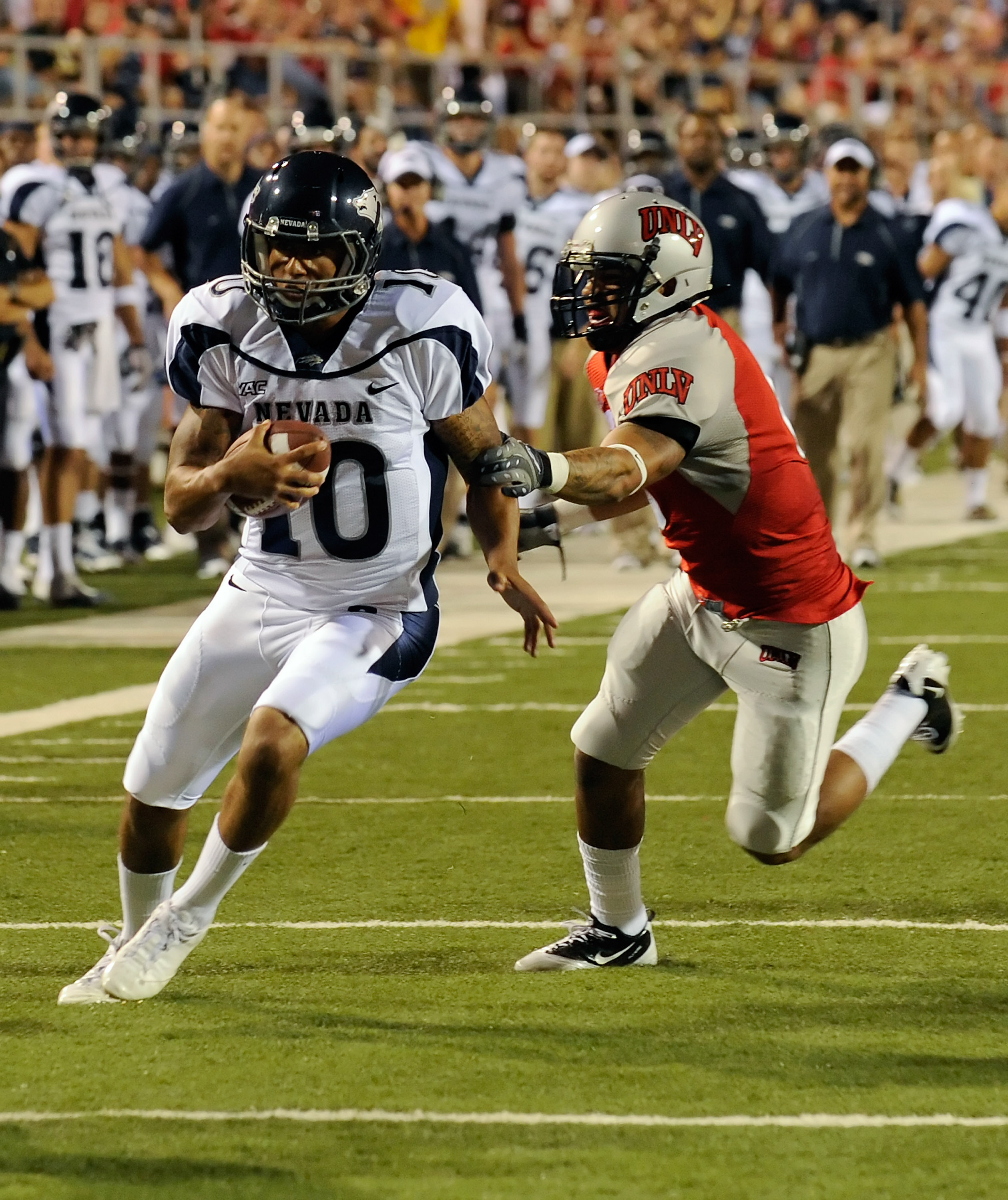 LAS VEGAS - OCTOBER 02: Quarterback Colin Kaepernick #10 of the Nevada Reno Wolf Pack gets away from Mike Clausen #6 of the UNLV Rebel en route to scoring a touchdown in the first quarter of their game at Sam Boyd Stadium October 2, 2010 in Las Vegas, Ne
