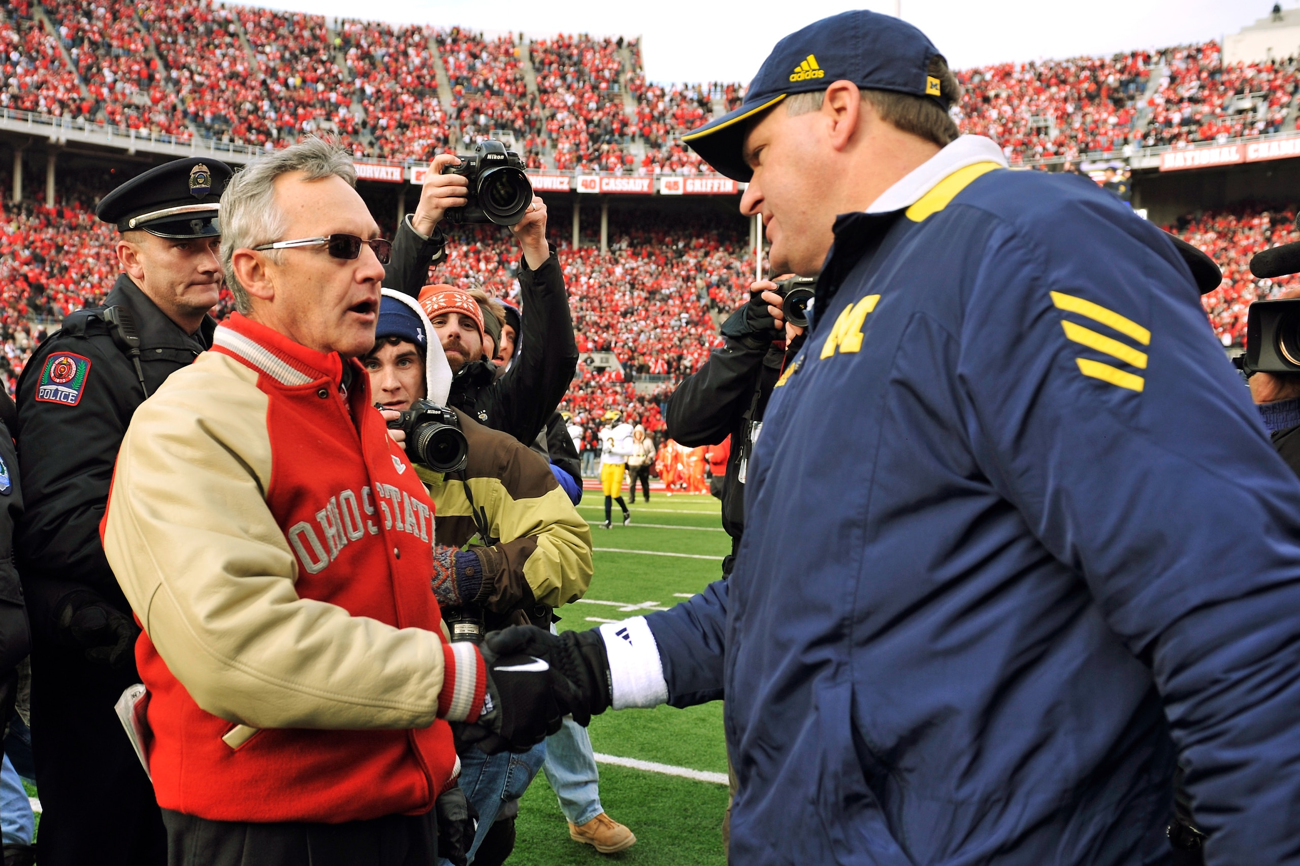 COLUMBUS, OH - NOVEMBER 27: Head Coach Jim Tressel of the Ohio State Buckeyes shakes hands with Head Coach Rich Rodriguez after the Buckeyes defeated the Wolverines 37-7 at Ohio Stadium on November 27, 2010 in Columbus, Ohio. (Photo by Jamie Sabau/Getty COLUMBUS, OH - NOVEMBER 27: Head Coach Jim Tressel of the Ohio State Buckeyes shakes hands with Head Coach Rich Rodriguez after the Buckeyes defeated the Wolverines 37-7 at Ohio Stadium on November 27, 2010 in Columbus, Ohio. (Photo by Jamie Sabau/Getty