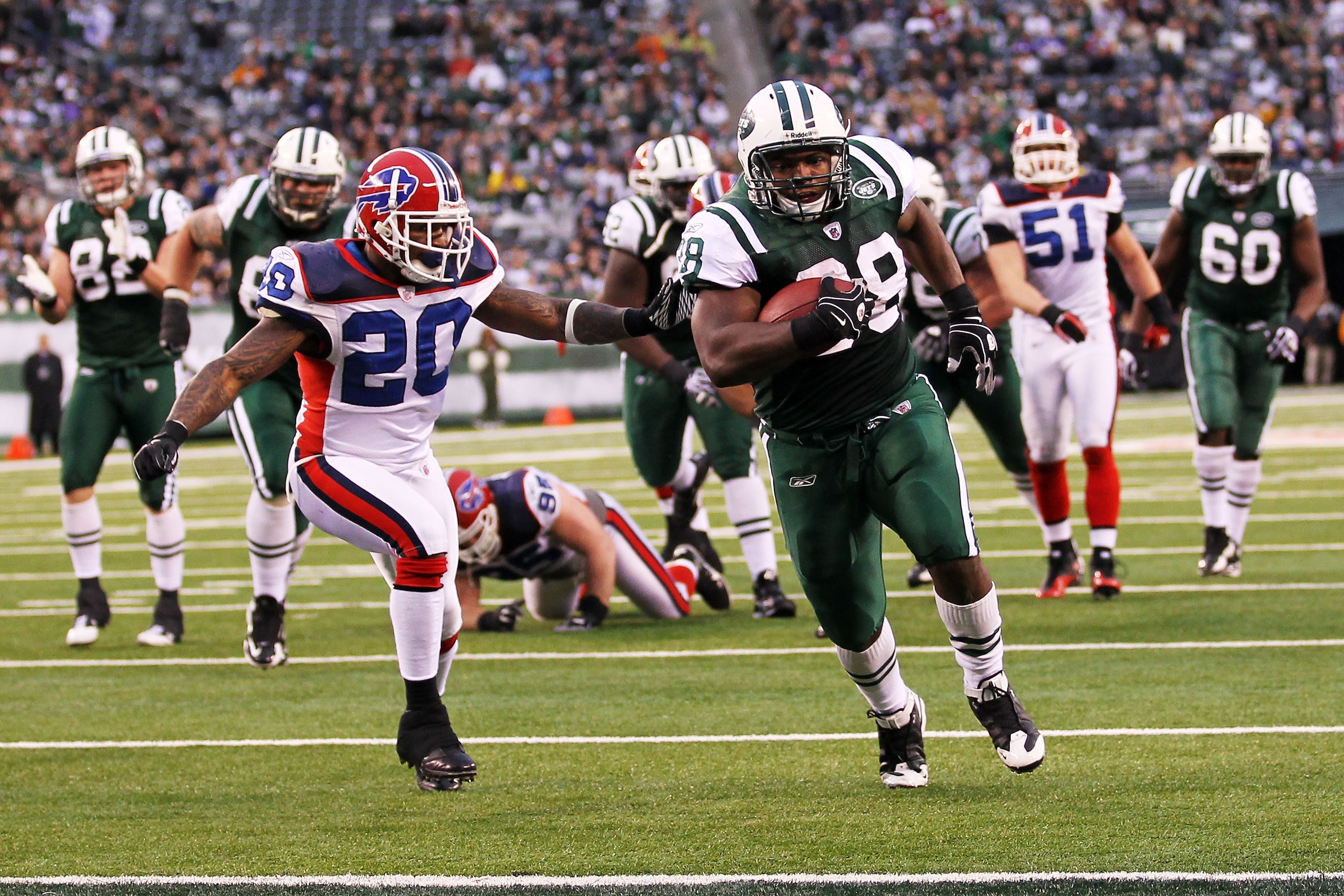 EAST RUTHERFORD, NJ - JANUARY 02:  John Conner #38 of the New York Jets runs for a touchdown against the defense of Donte Whitner #20 of the Buffalo Bills at New Meadowlands Stadium on January 2, 2011 in East Rutherford, New Jersey.  (Photo by Al Bello/Ge