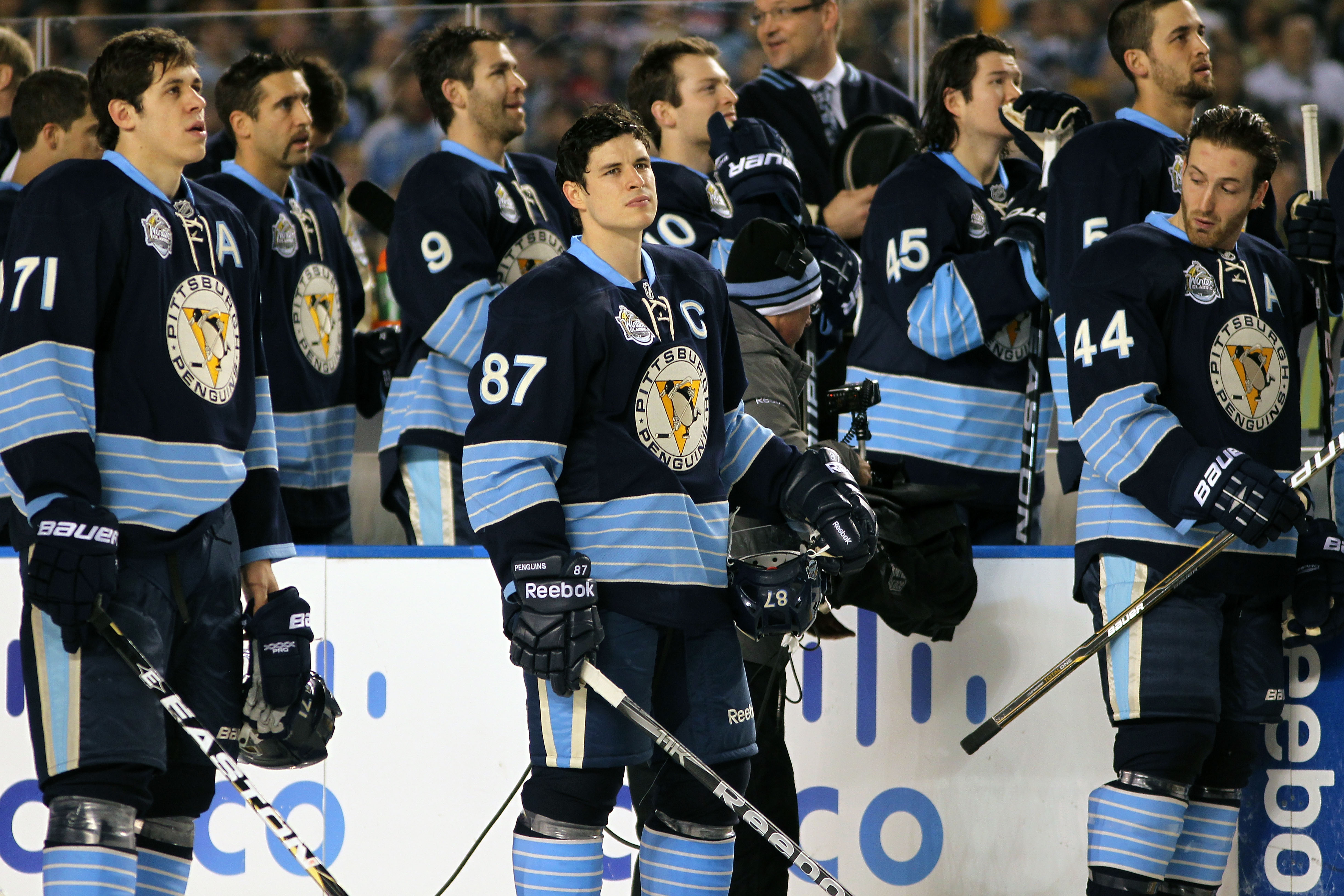 PITTSBURGH, PA - JANUARY 01:  Evgeni Malkin #71, Sidney Crosby #87 and Brooks Orpik #44 of the Pittsburgh Penguins look on during opening ceremonies before the start of the 2011 NHL Bridgestone Winter Classic against the Washington Capitals at Heinz Field