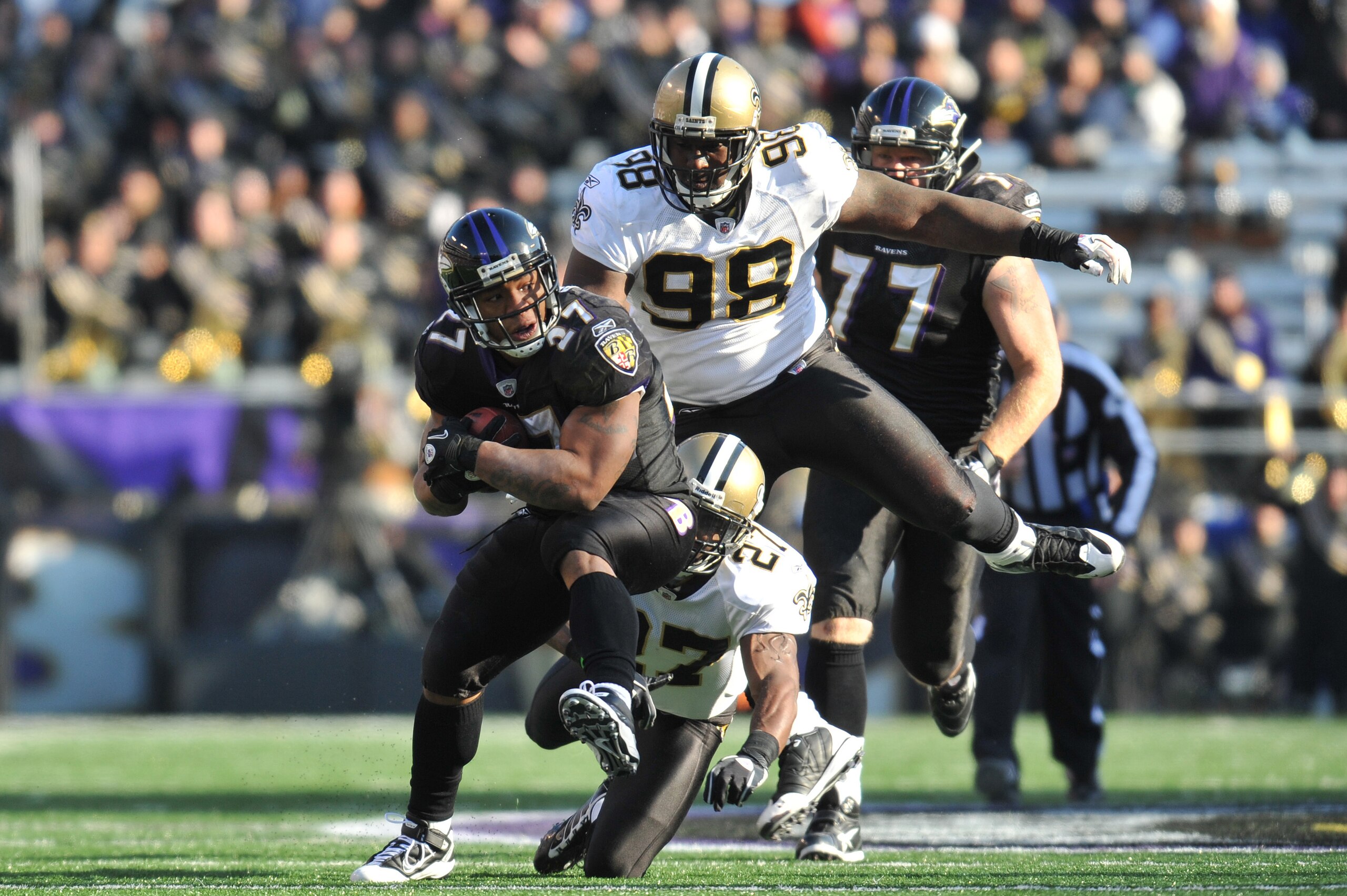 BALTIMORE, MD - DECEMBER 19:  Ray Rice #27 of the Baltimore Ravens runs the ball while Sedrick Ellis #98 of the New Orleans Saints   defends at M&T Bank Stadium on December 19, 2010 in Baltimore, Maryland. The Ravens defeated the Saints 30-24. (Photo by L