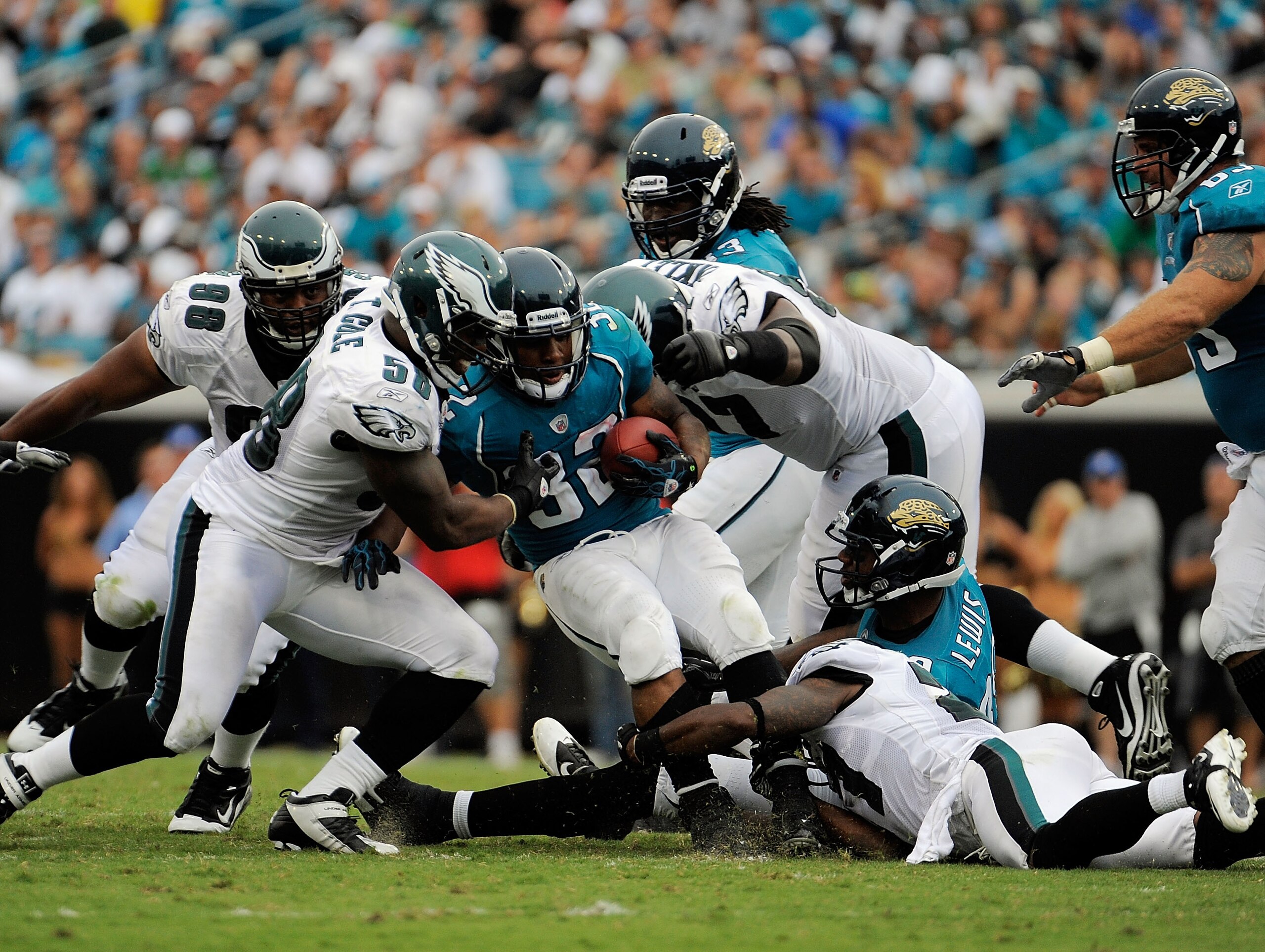 JACKSONVILLE, FL - SEPTEMBER 26:  Linebacker Trent Cole #58 and defensive tackle Brodrick Bunkley #97 of the Philadelphia Eagles bring down running back Maurice Jones-Drew #32 of the Jacksonville Jaguars at EverBank Field on September 26, 2010 in Jacksonv
