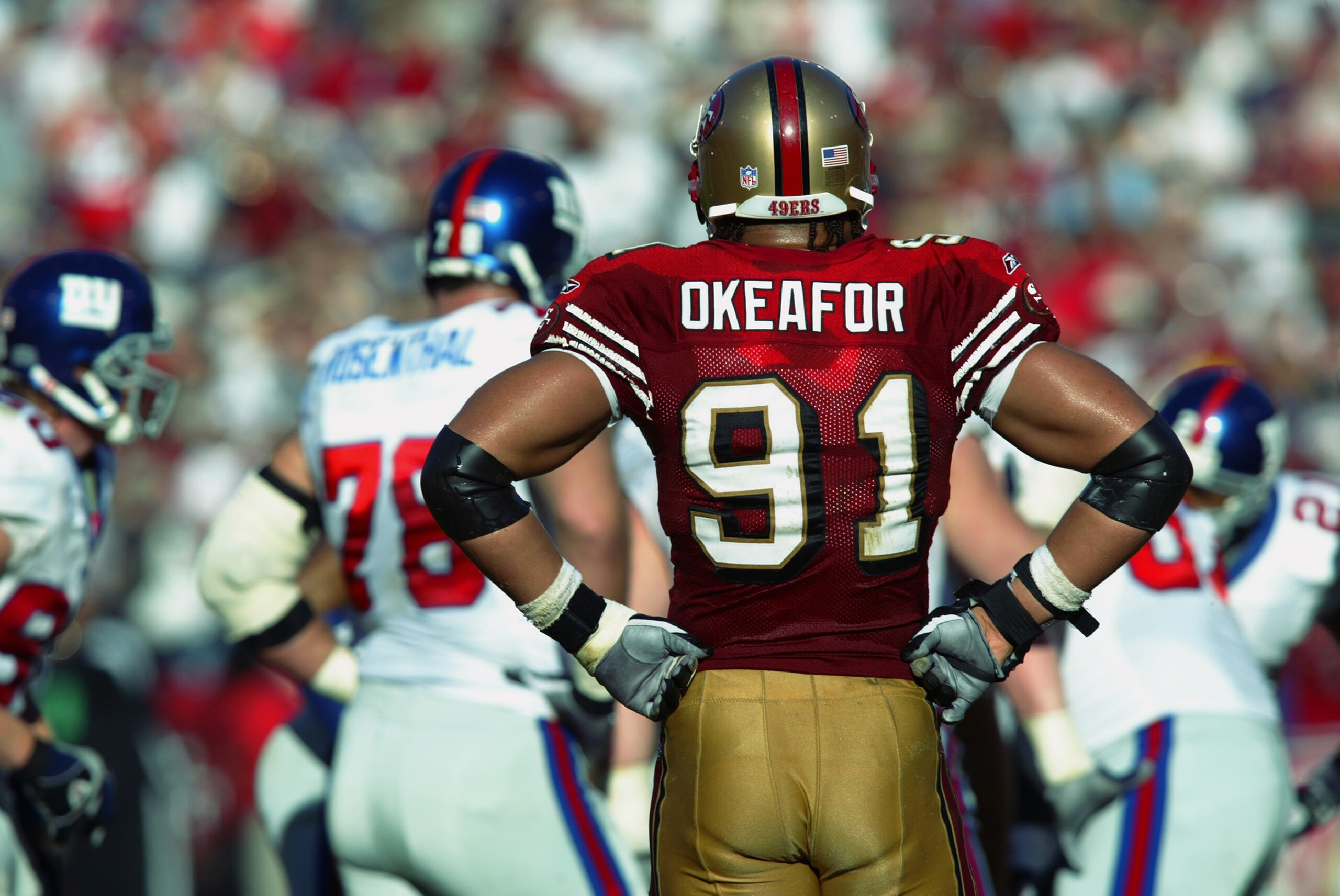SAN FRANCISCO - JANUARY 5:  Defensive end Chike Okeafor #91 of the San Francisco 49ers stands in front of the New York Giants offense after sacking the quarterback during the NFC Wild Card game at 3Com Park on January 5, 2003 in San Francisco, California.