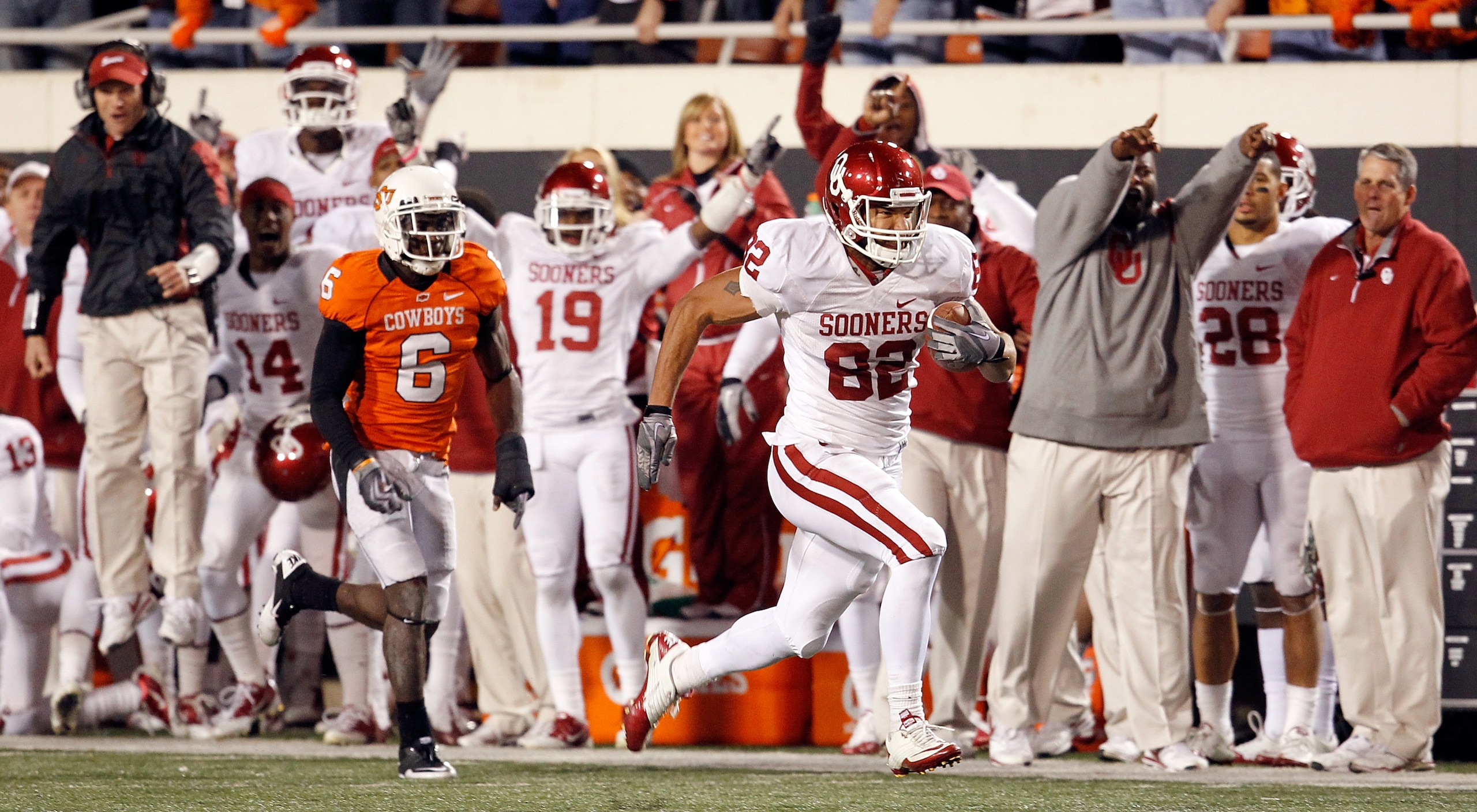 STILLWATER, OK - NOVEMBER 27:  Tightend James Hanna #82 of the Oklahoma Sooners beats out cornerback Andrew McGee #6 of the Oklahoma State Cowboys to score at Boone Pickens Stadium on November 27, 2010 in Stillwater, Oklahoma.  The Sooners beat the Cowboy