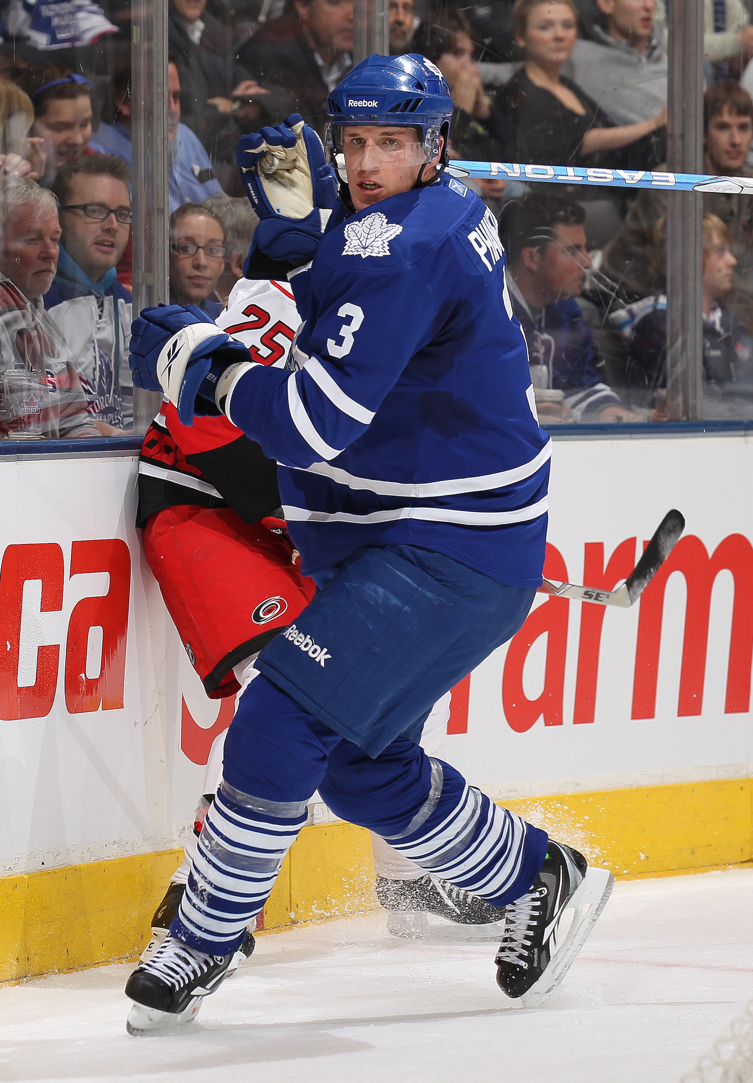TORONTO,ON - DECEMBER 28:  Joni Pitkanen #25 of the Carolina Hurricanes takes a big hit from Dion Phaneuf #3 of the Toronto Maple Leafs in a game on December 28, 2010 at the Air Canada Centre in Toronto, Ontario. (Photo by Claus Andersen/Getty Images)