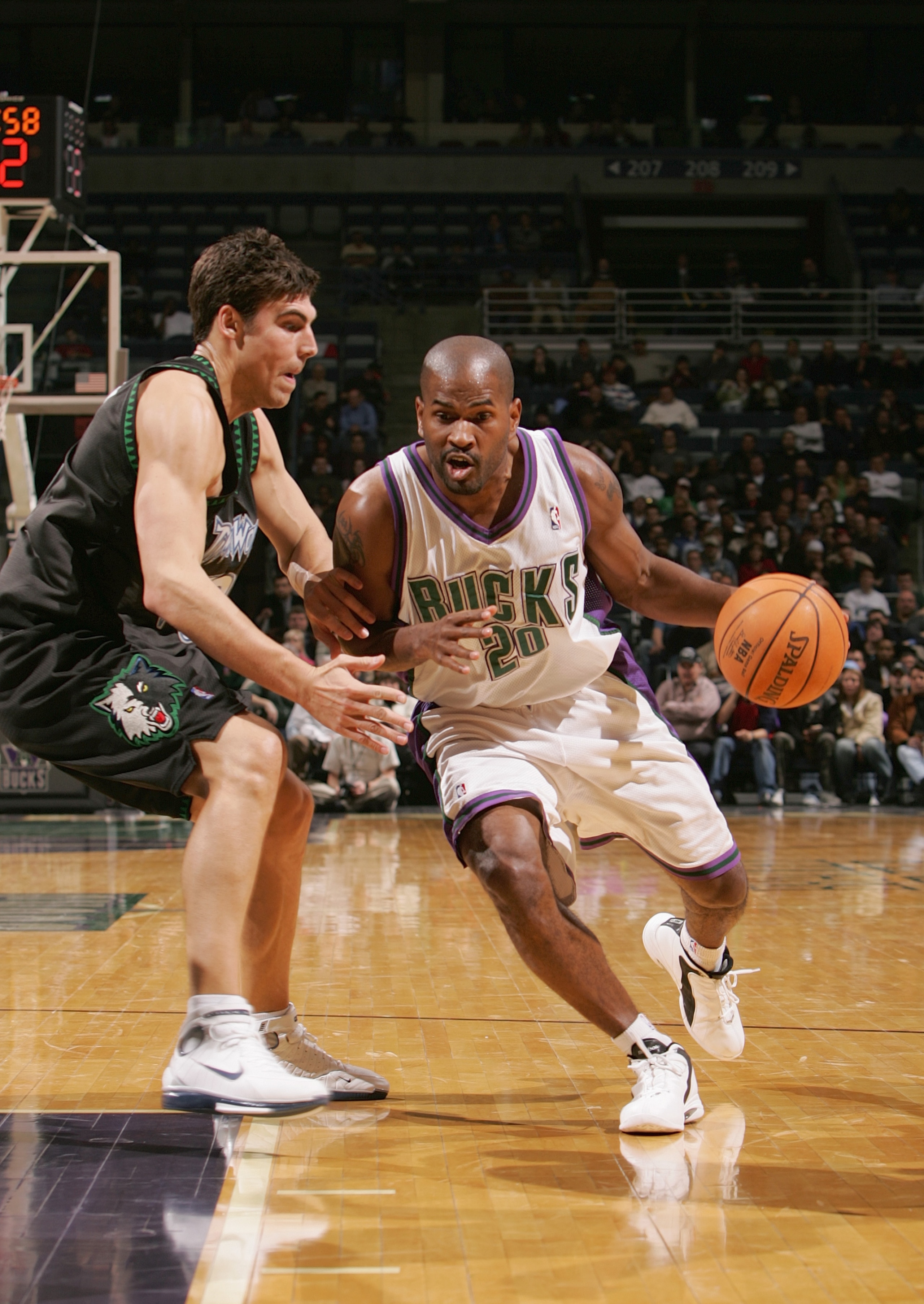 MILWAUKEE - FEBRUARY 1:  Erick Strickland #20 of the Milwaukee Bucks drives against Wally Szczerbiak #10 of the Minnesota Timberwolves on February 1, 2005 at Bradley Center in Milwaukee, Wisconsin. The Bucks defeated the Wolves 91-86.  NOTE TO USER: User
