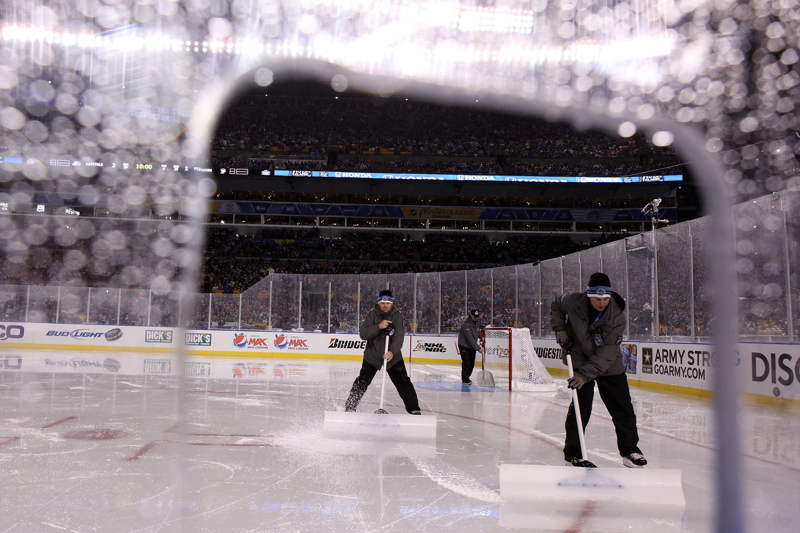 PITTSBURGH, PA - JANUARY 01:  Members of the ice crew maintain the ice during the 2011 NHL Bridgestone Winter Classic between the Washington Capitals and the Pittsburgh Penguins at Heinz Field on January 1, 2011 in Pittsburgh, Pennsylvania.  (Photo by Jam