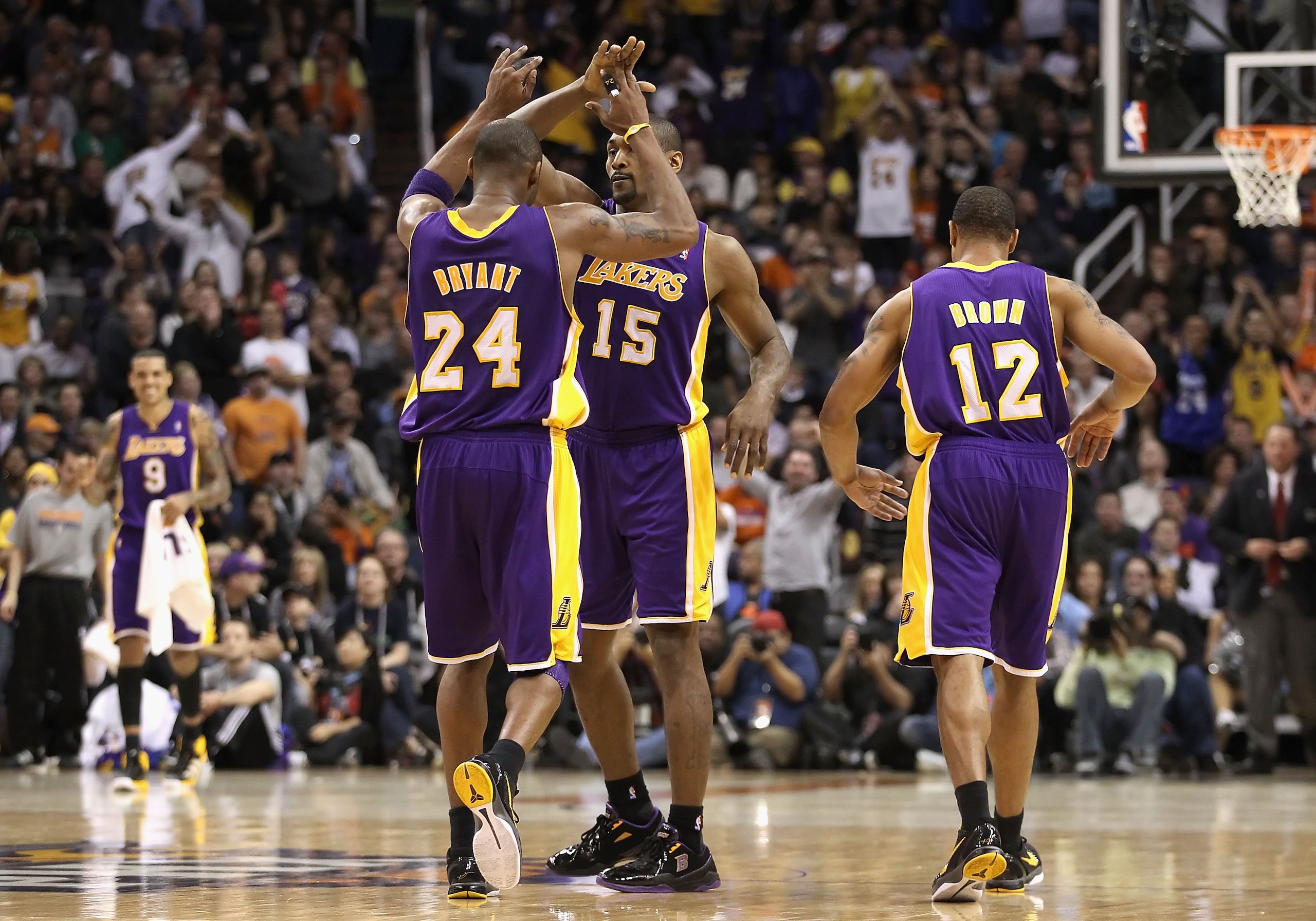 PHOENIX - JANUARY 05:  Kobe Bryant #24 of the Los Angeles Lakers high fives teammate Ron Artest after Artest hit a late three point shot against the Phoenix Suns during the NBA game at US Airways Center on December 23, 2011 in Phoenix, Arizona. The Lakers