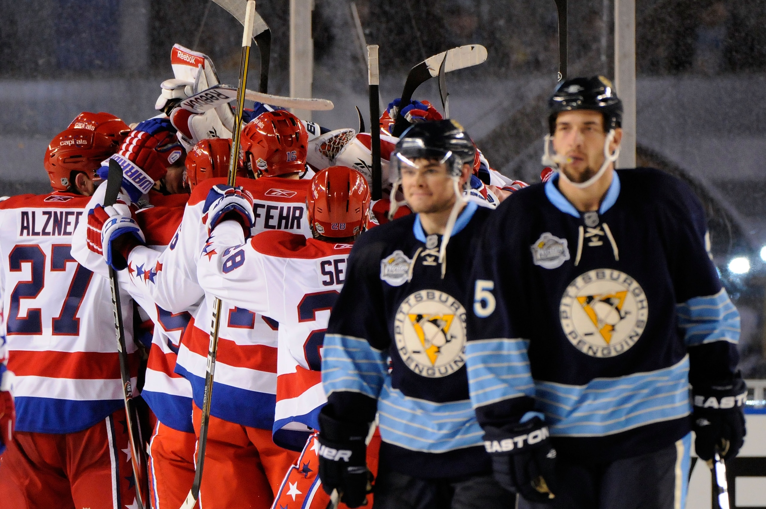 PITTSBURGH, PA - JANUARY 01:  The Washington Capitals celebrate their 3-1 victory as the Pittsburgh Penguins leave the ice during the 2011 NHL Bridgestone Winter Classic at Heinz Field on January 1, 2011 in Pittsburgh, Pennsylvania.  (Photo by Jamie Sabau