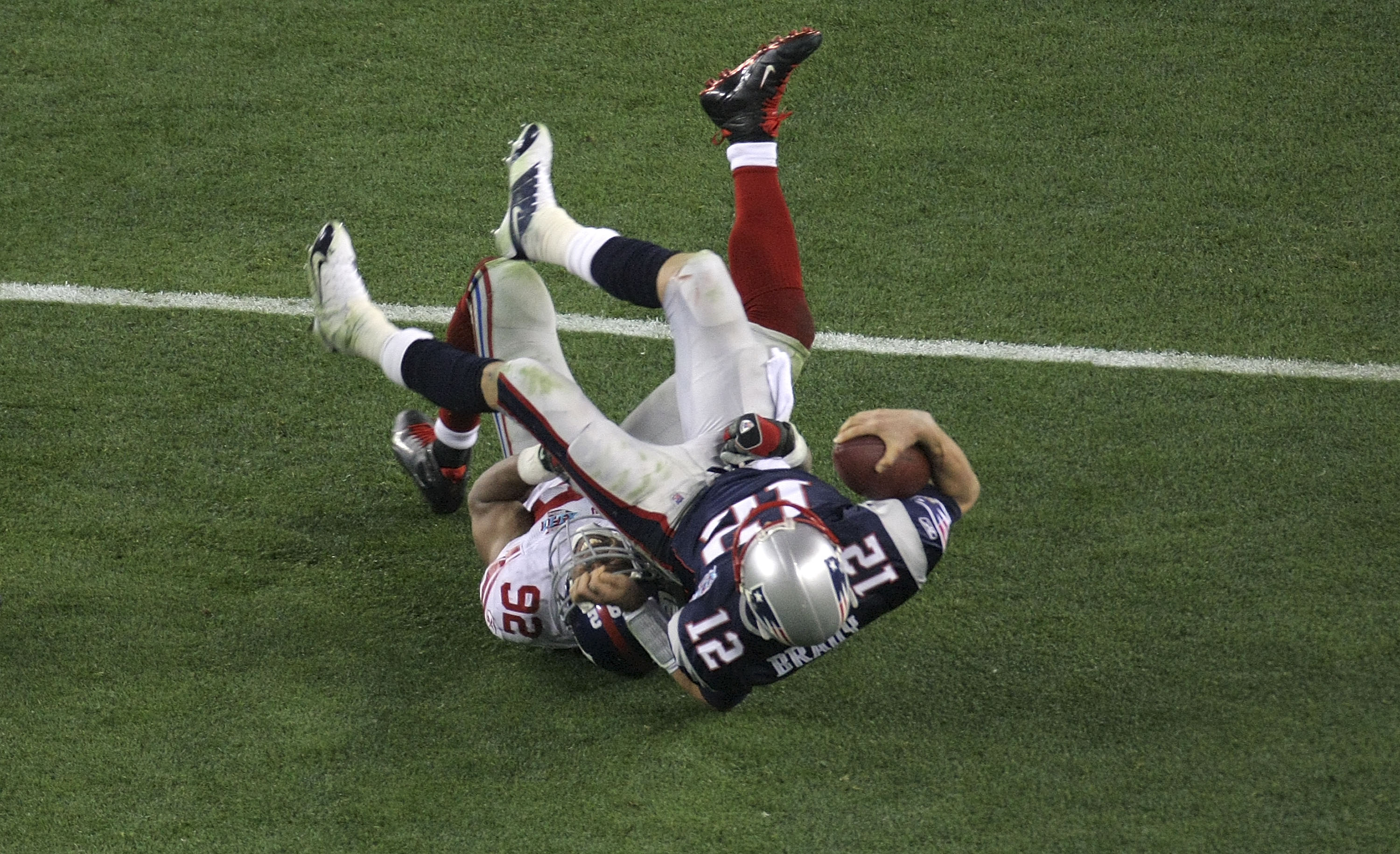 GLENDALE, AZ - FEBRUARY 03:  Quarterback Tom Brady #12 of the New England Patriots lies on his back after being sacked by defensive end Michael Strahan #92 of the New York Giants in the third quarter during Super Bowl XLII on February 3, 2008 at the Unive