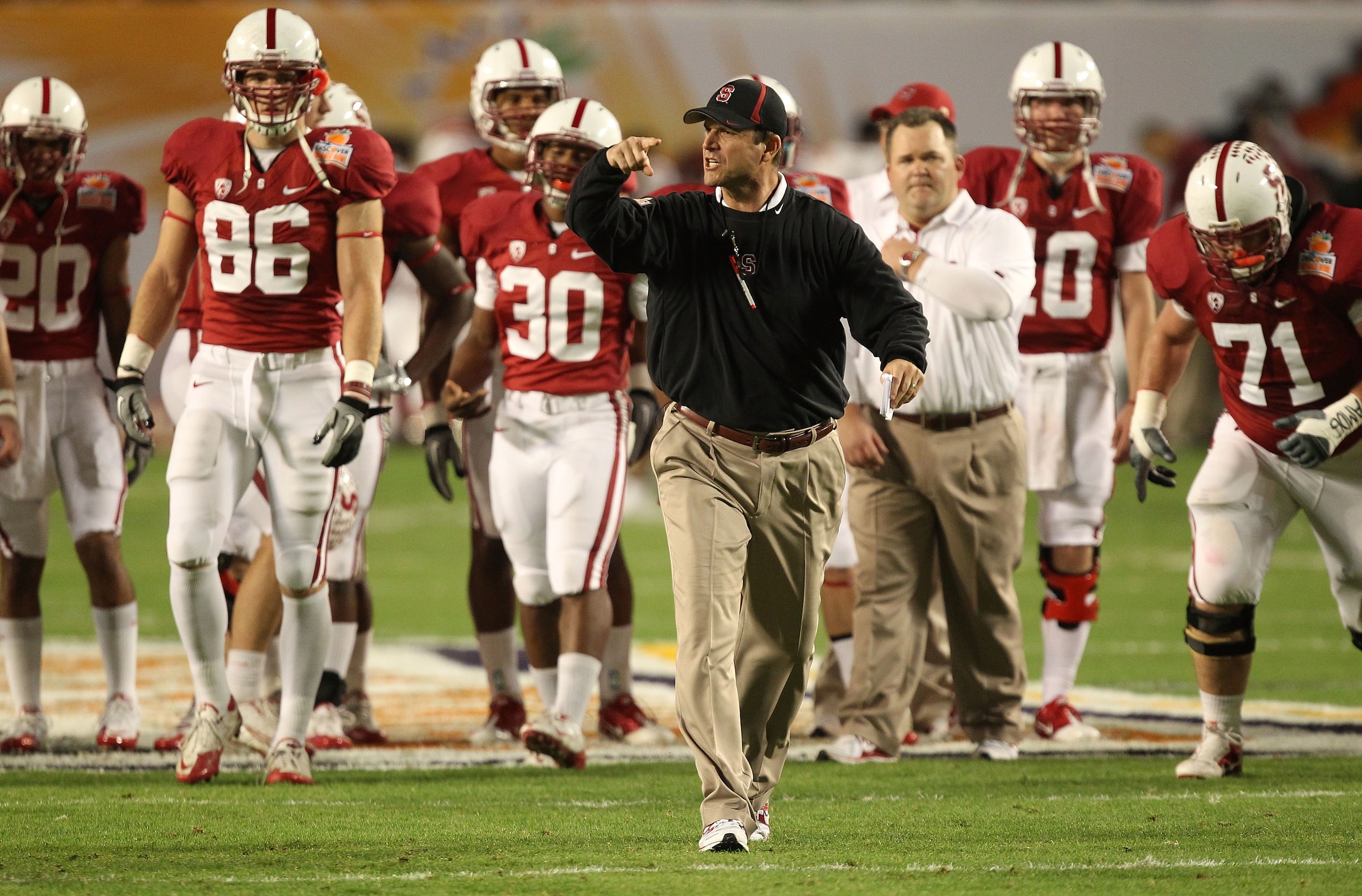 MIAMI, FL - JANUARY 03:  Head coach Jim Harbaugh of the Stanford Cardinal instructs his players during warm ups against the Virginai Tech Hokies during the 2011 Discover Orange Bowl at Sun Life Stadium on January 3, 2011 in Miami, Florida.  (Photo by Stre