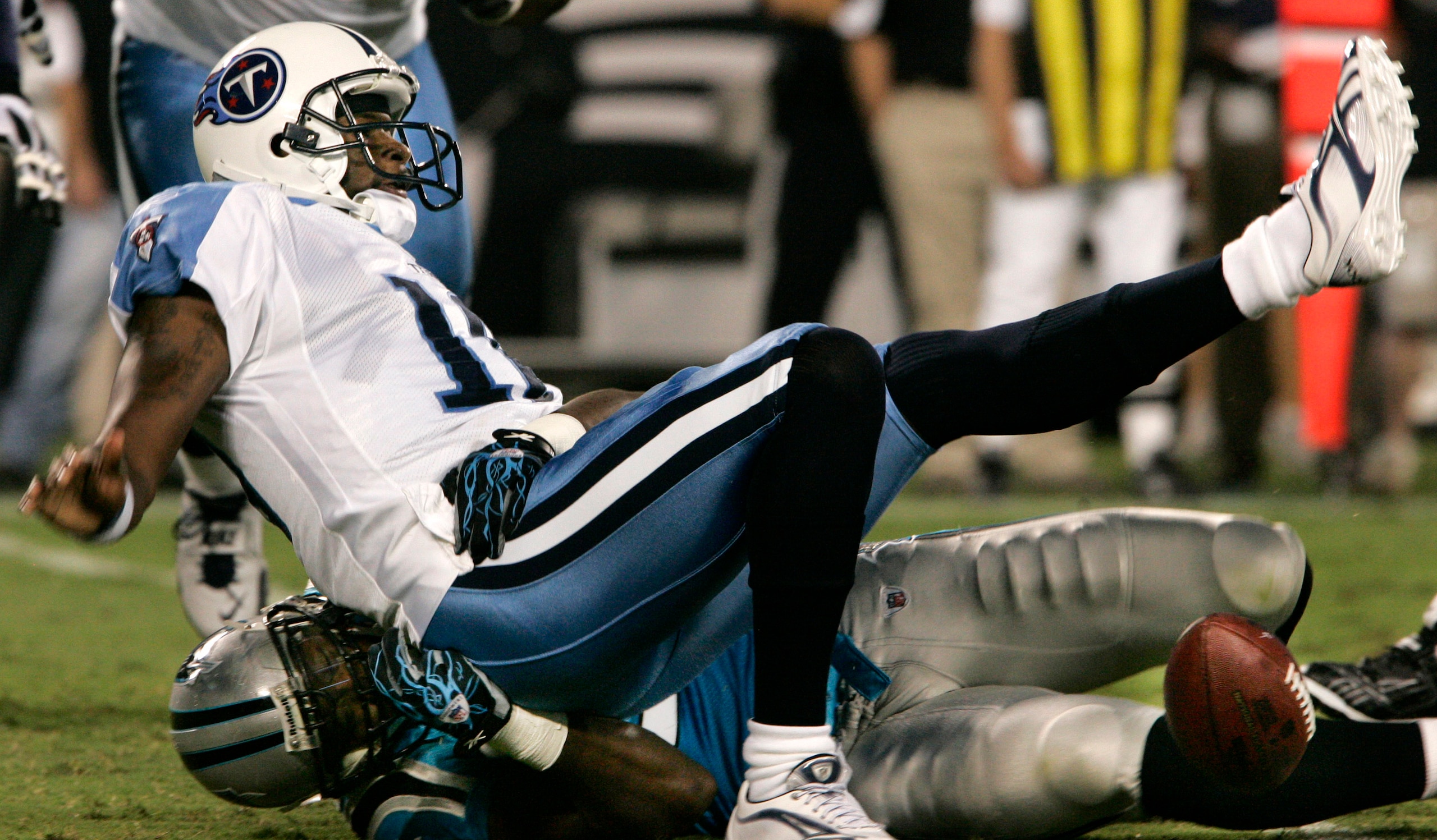 CHARLOTTE, NC - AUGUST 28:  Quarterback Vince Young #10 of the Tennessee Titans looses the ball as he is sacked by Everette Brown #91 of the Carolina Panthers during their preseason game at Bank of America Stadium on August 28, 2010 in Charlotte, North Ca