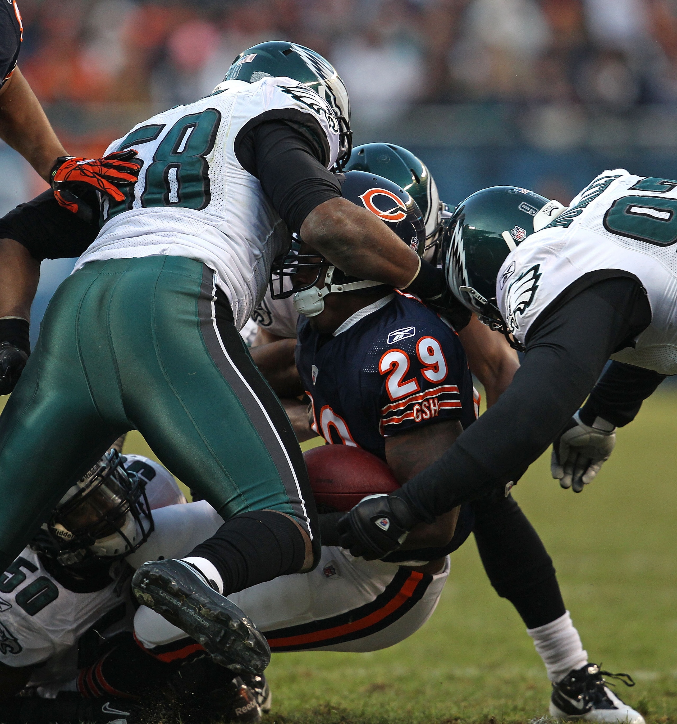 CHICAGO - NOVEMBER 28: Chester Taylor #29 of the Chicago Bears is stopped by Trent Cole #58 and Brodrick Bunkley #97 of the Philadelphia Eagles at Soldier Field on November 28, 2010 in Chicago, Illinois. The Bears defeated the Eagles 31-26. (Photo by Jona