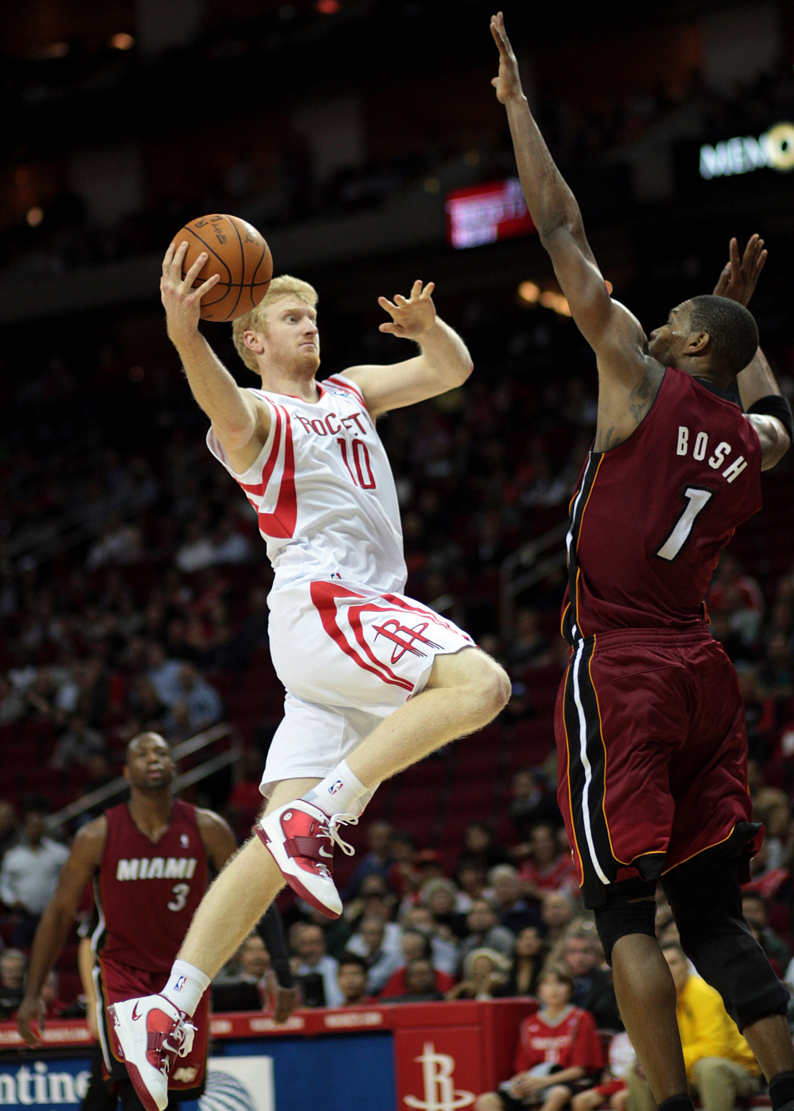 HOUSTON - DECEMBER 29: Chase Budinger #10 of the Houston Rockets drives the basket over Chris Bosh #1 of the Miami Heat in the second half at Toyota Center on December 29, 2010 in Houston, Texas. Miami won 125-119. NOTE TO USER: User expressly acknowledge HOUSTON - DECEMBER 29: Chase Budinger #10 of the Houston Rockets drives the basket over Chris Bosh #1 of the Miami Heat in the second half at Toyota Center on December 29, 2010 in Houston, Texas. Miami won 125-119. NOTE TO USER: User expressly acknowledge