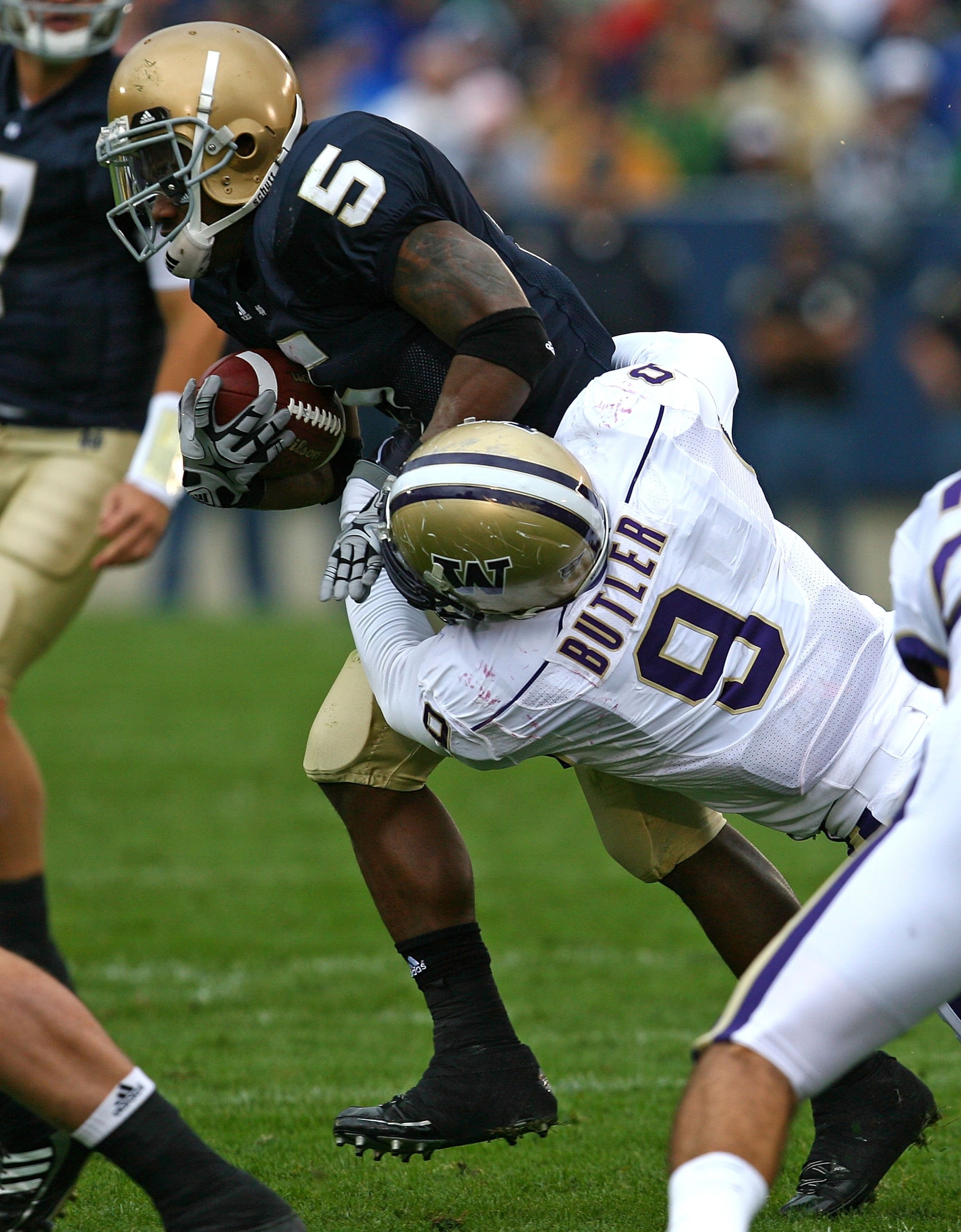 SOUTH BEND, IN - OCTOBER 03: Armando Allen #5 of the Notre Dame Fighting Irish is tackled by Donald Butler #9 of the Washington Huskies on October 3, 2009 at Notre Dame Stadium in South Bend, Indiana. Notre Dame defeated Washington 37-30 in overtime.  (Ph