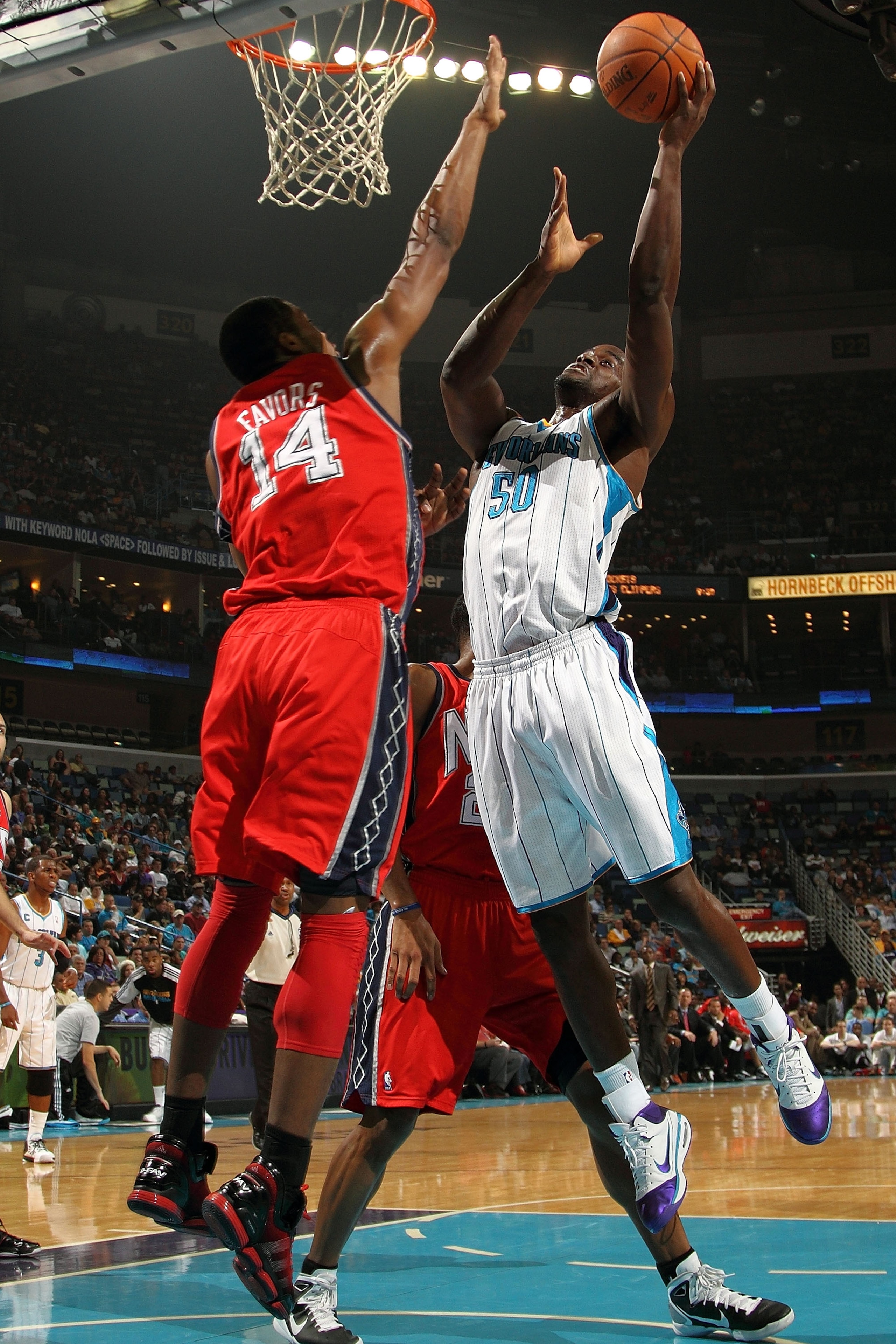 NEW ORLEANS, LA - DECEMBER 22: Emeka Okafor #50 of the New Orleans Hornets shoots the ball over Derrick Favors #14 of the New Jersey Nets at the New Orleans Arena on December 22, 2010 in New Orleans, Louisiana. NOTE TO USER: User expressly acknowledges NEW ORLEANS, LA - DECEMBER 22: Emeka Okafor #50 of the New Orleans Hornets shoots the ball over Derrick Favors #14 of the New Jersey Nets at the New Orleans Arena on December 22, 2010 in New Orleans, Louisiana. NOTE TO USER: User expressly acknowledges